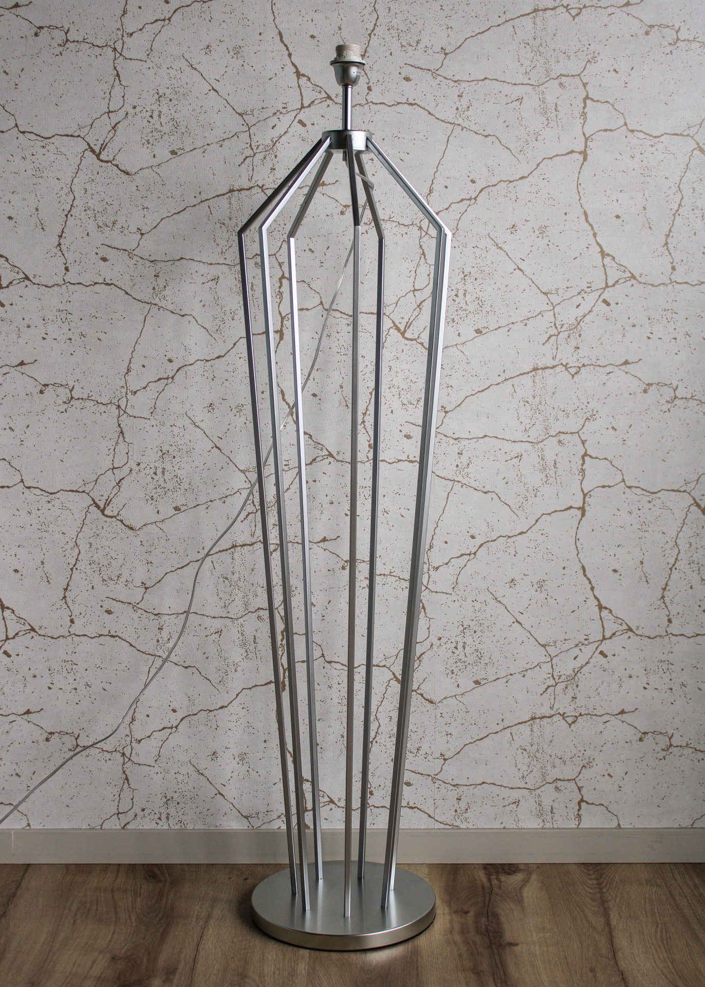 Candeeiro moderno em metal prateado com estrutura aberta e base redonda