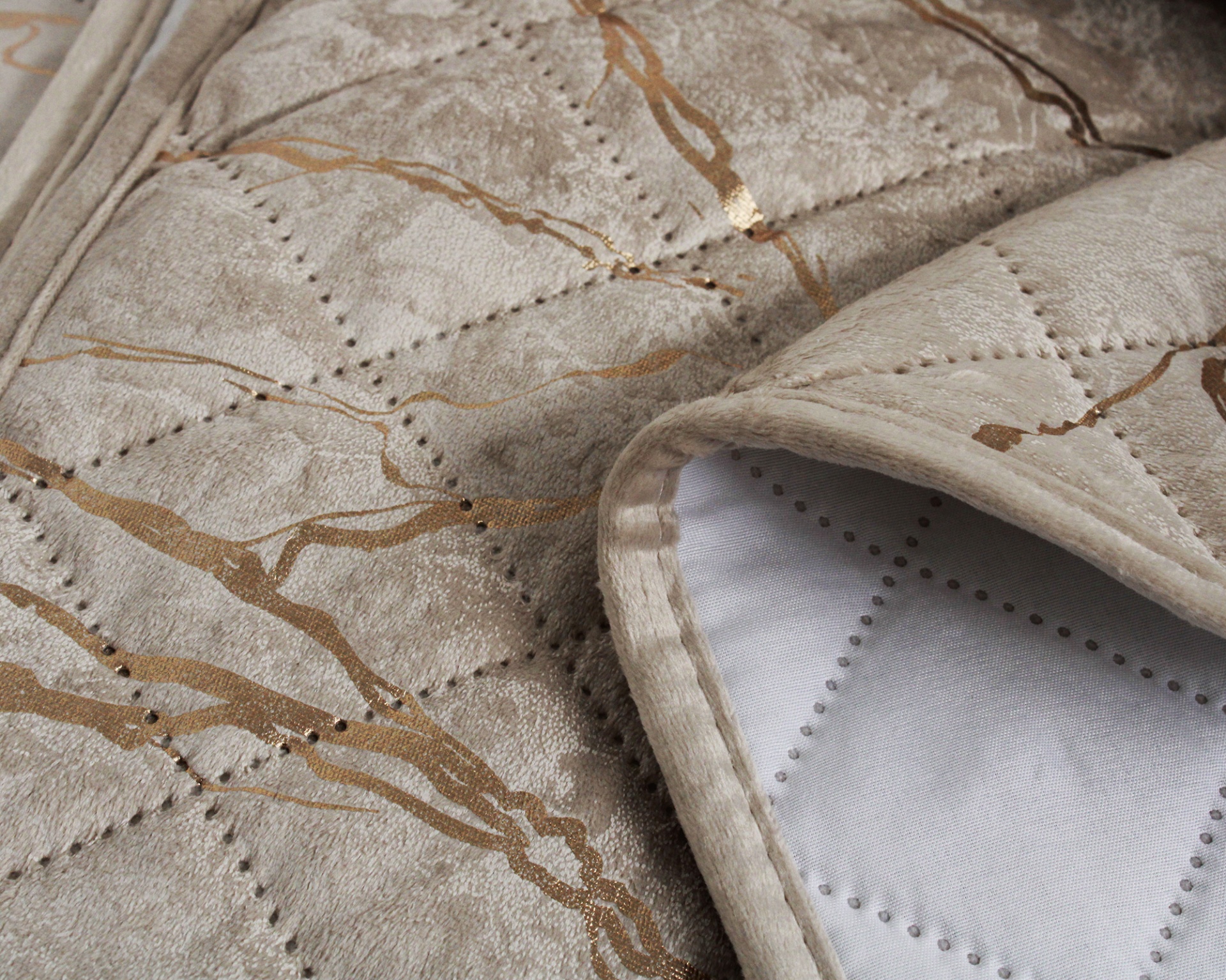 Tapete bege com padrão dourado e costura em close-up