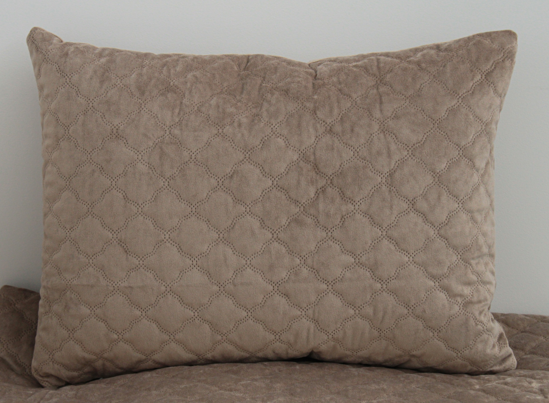 Almofada bege com padrão de costura em losangos