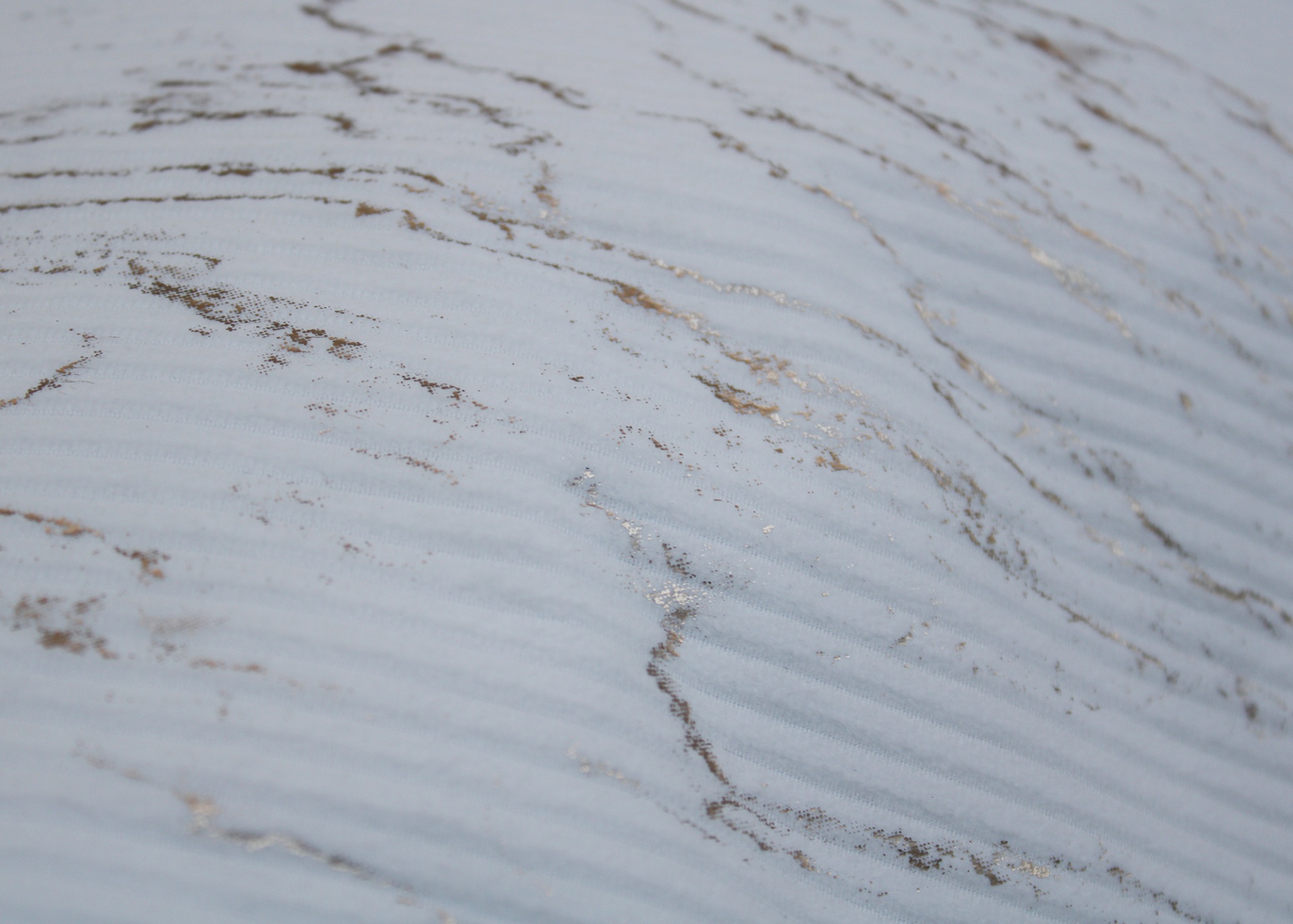 tecido branco com riscas e manchas castanhas