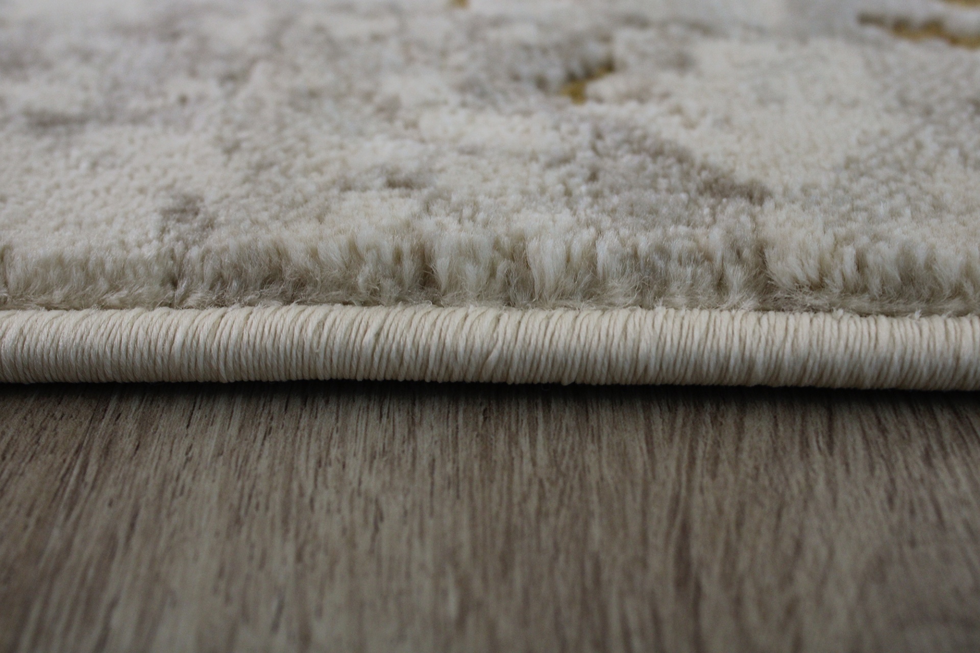 Tapete bege sobre chão de madeira escura