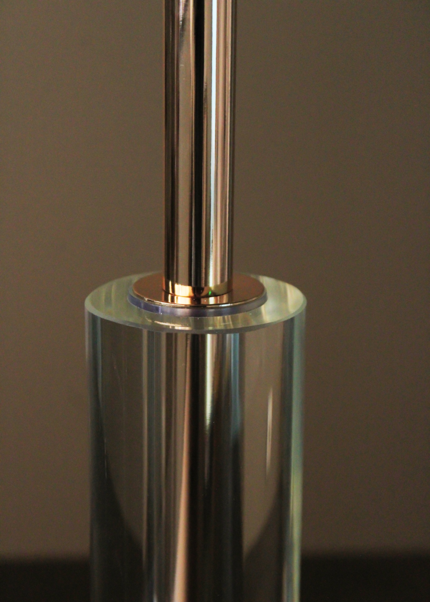 Base cilíndrica transparente com estrutura metálica prateada