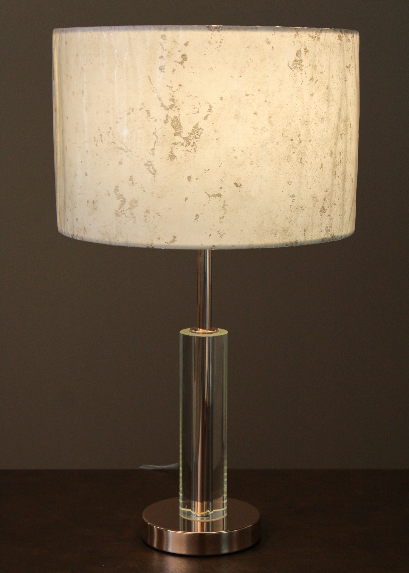 Candeeiro de mesa com cúpula bege manchada e base metálica cilíndrica