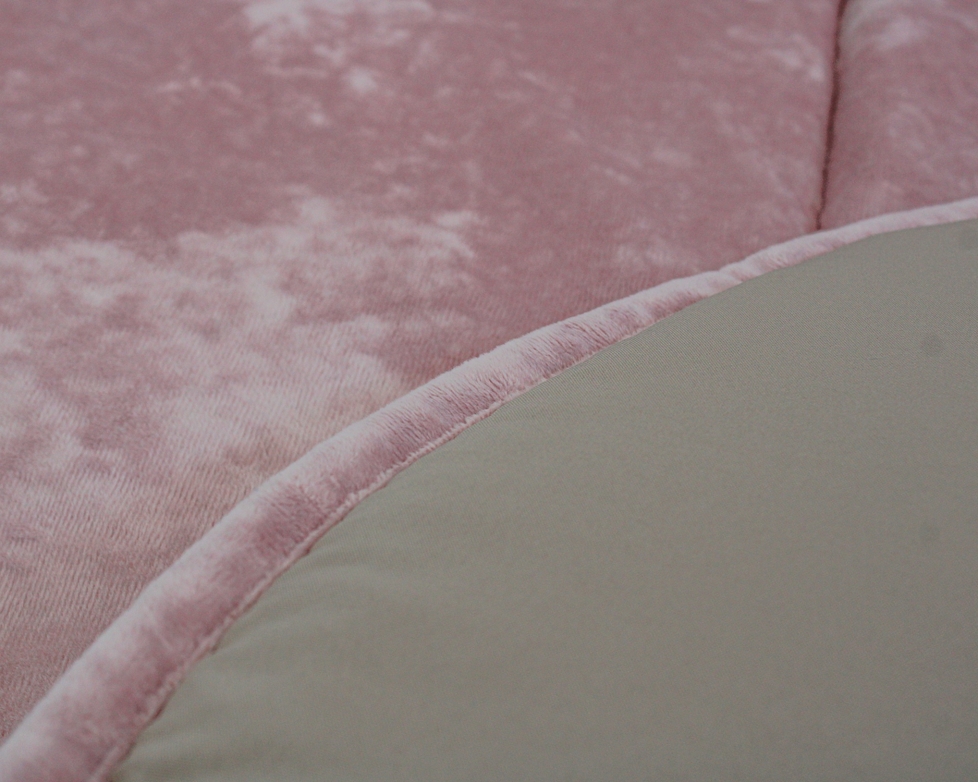 Detalhe de tecido rosa aveludado com borda curva e material cinzento-bege