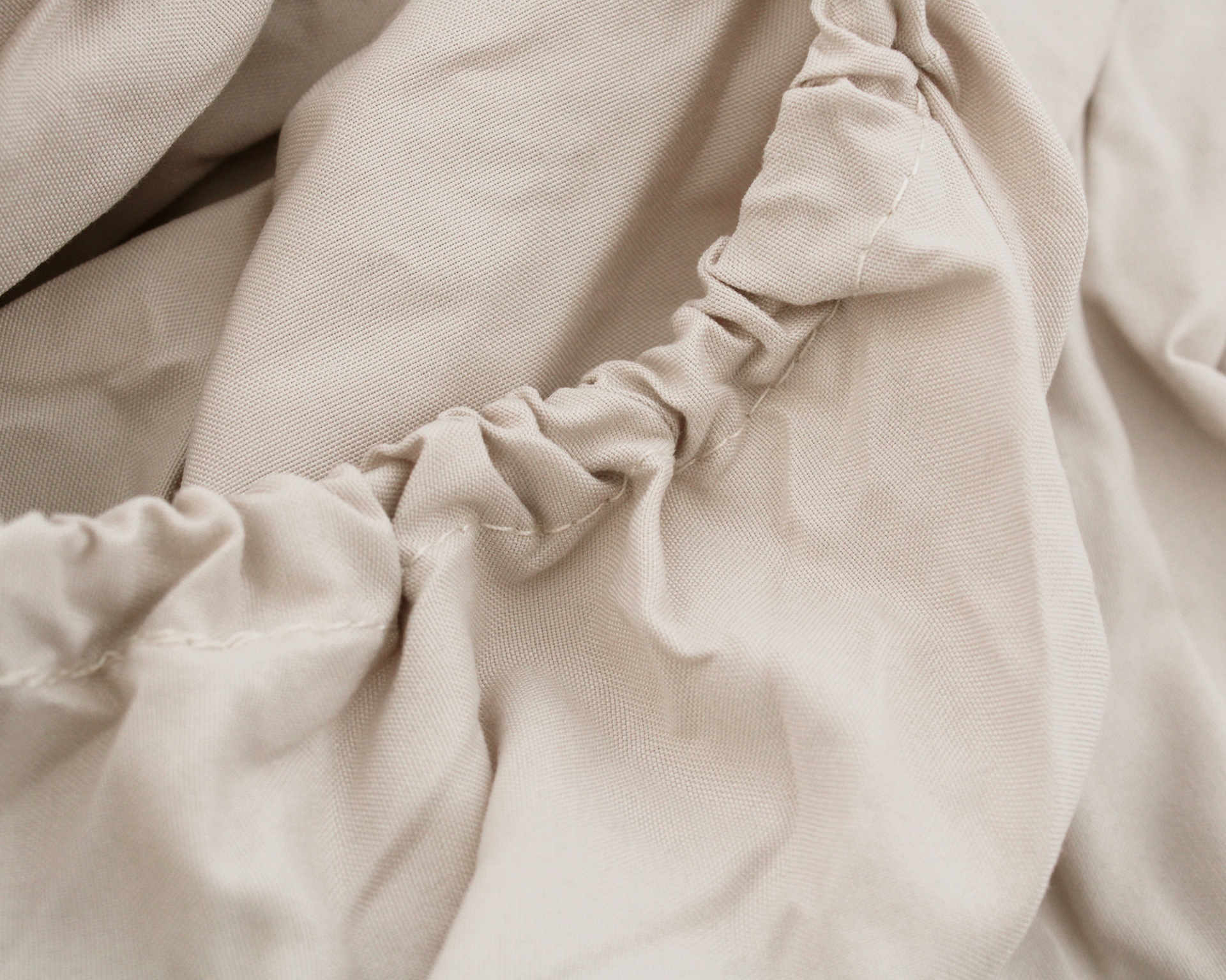 Tecido bege claro com costura elástica franzida