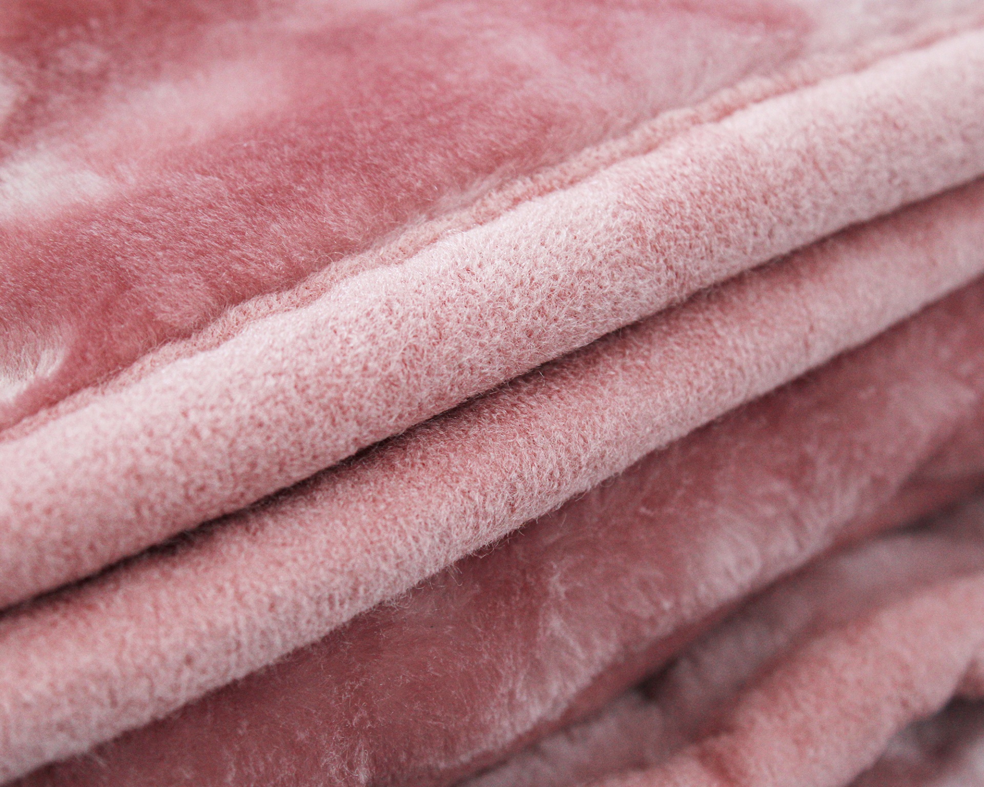 Cobertor ou manta rosa claro dobrado com textura felpuda