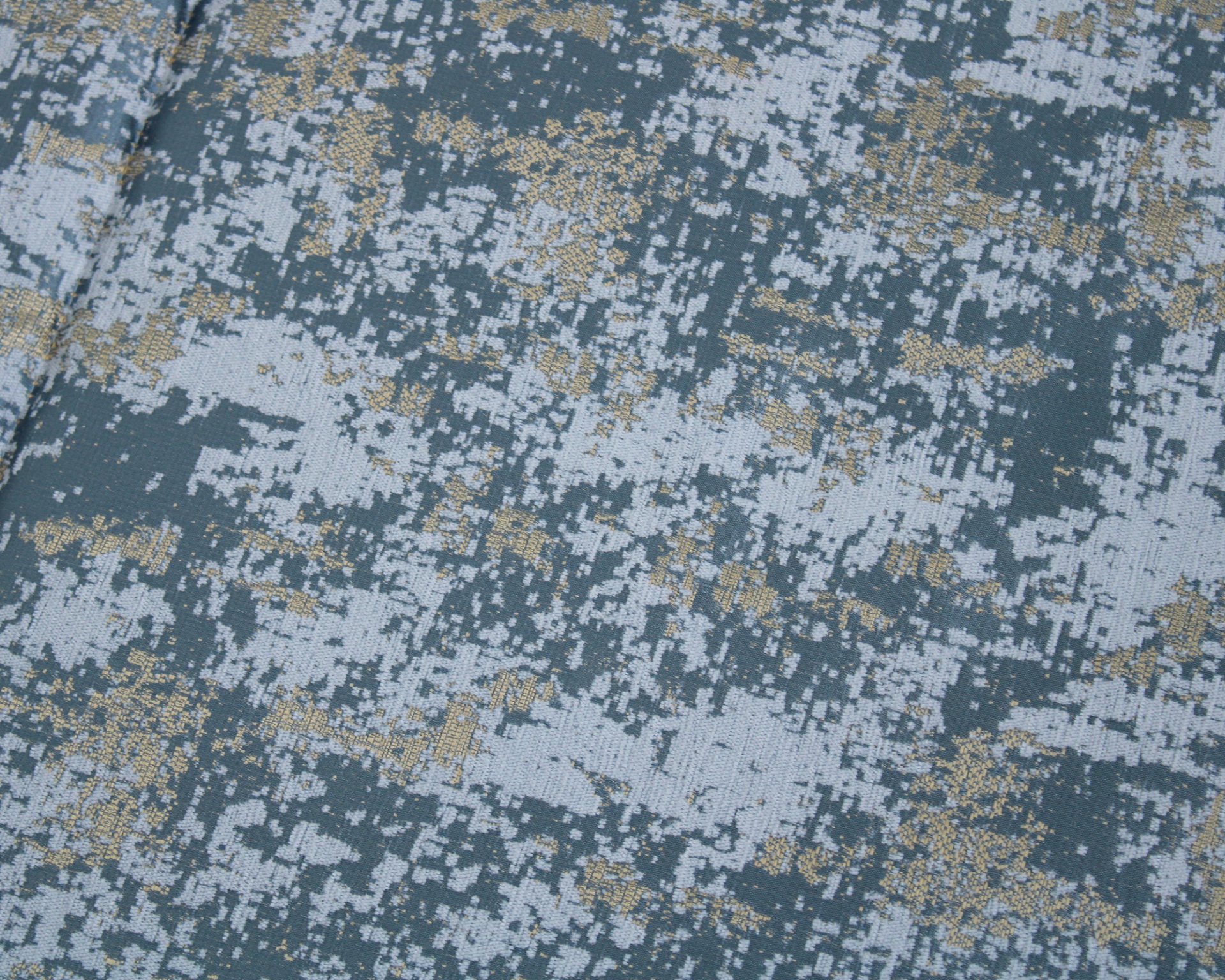 Tecido com padrão pixelado digital em tons de azul, cinza e dourado.