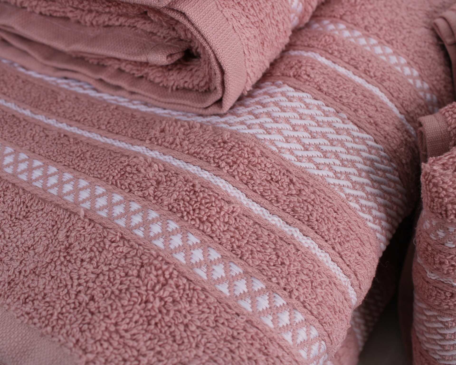Toalhas de banho rosa velho com padrões decorativos e textura felpuda