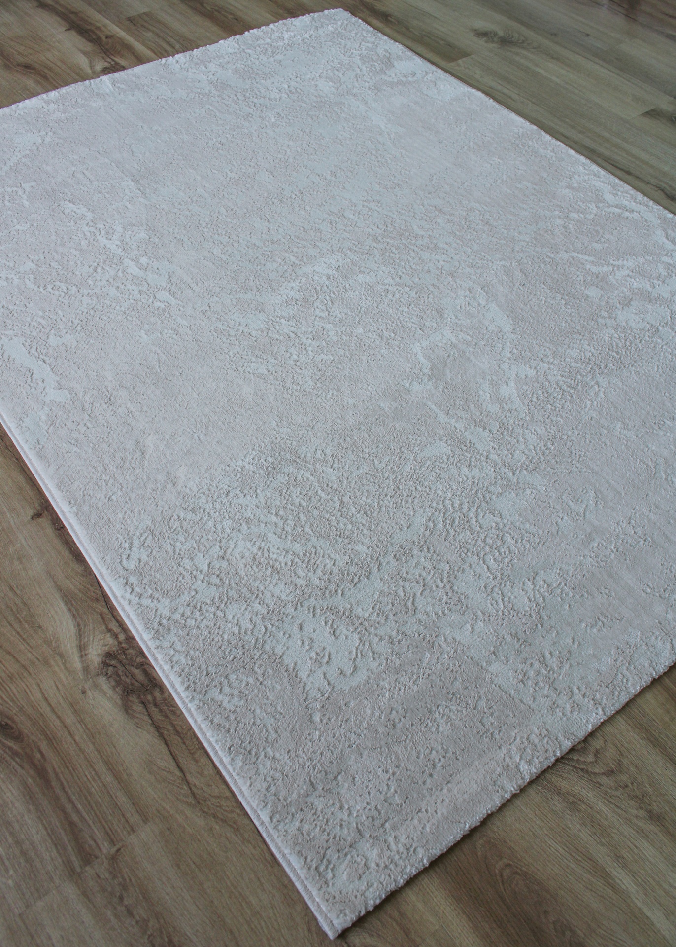 Tapete cinza claro texturizado num chão de madeira
