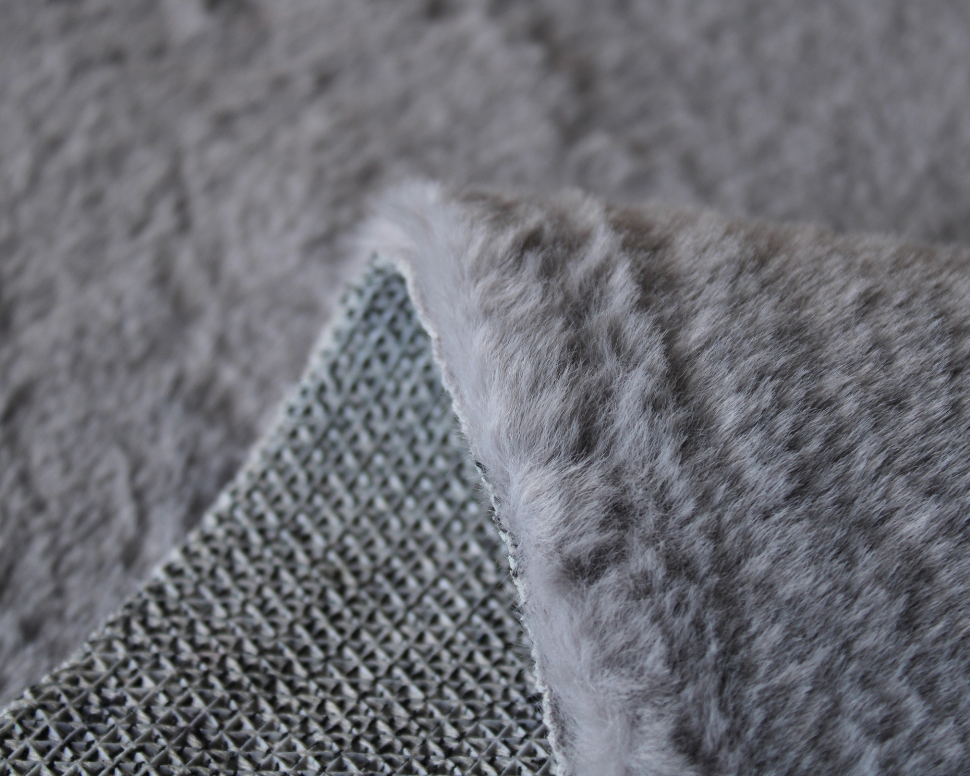 Tapete cinza com textura aveludada e lado inferior tecido