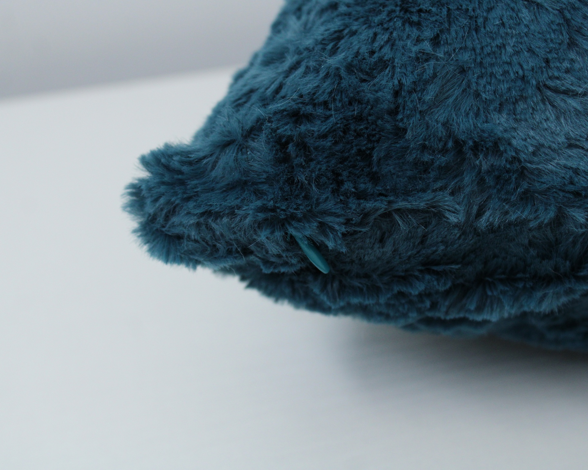 Almofada azul escura felpuda com botão decorativo