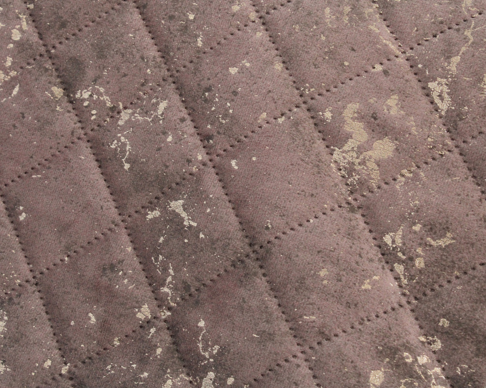 tecido acolchoado castanho com manchas claras e desgaste