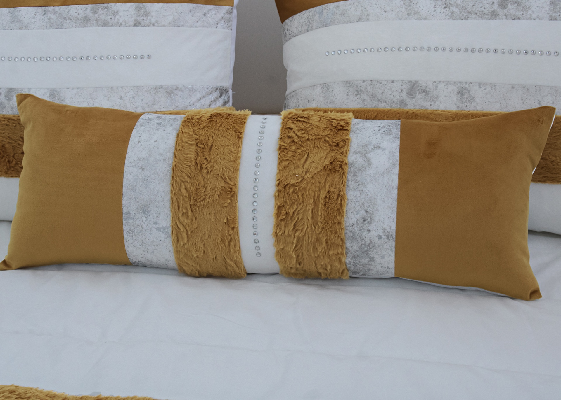 Travesseiro retangular com tecido amarelo, branco com cinza, pelúcia e pedras prateadas