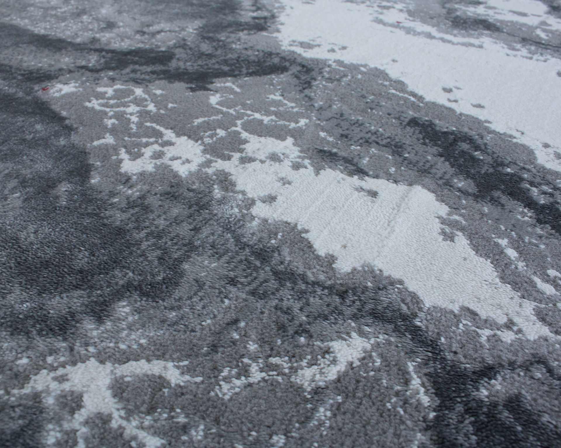 Tapete cinza e branco com padrão abstrato e textura felpuda