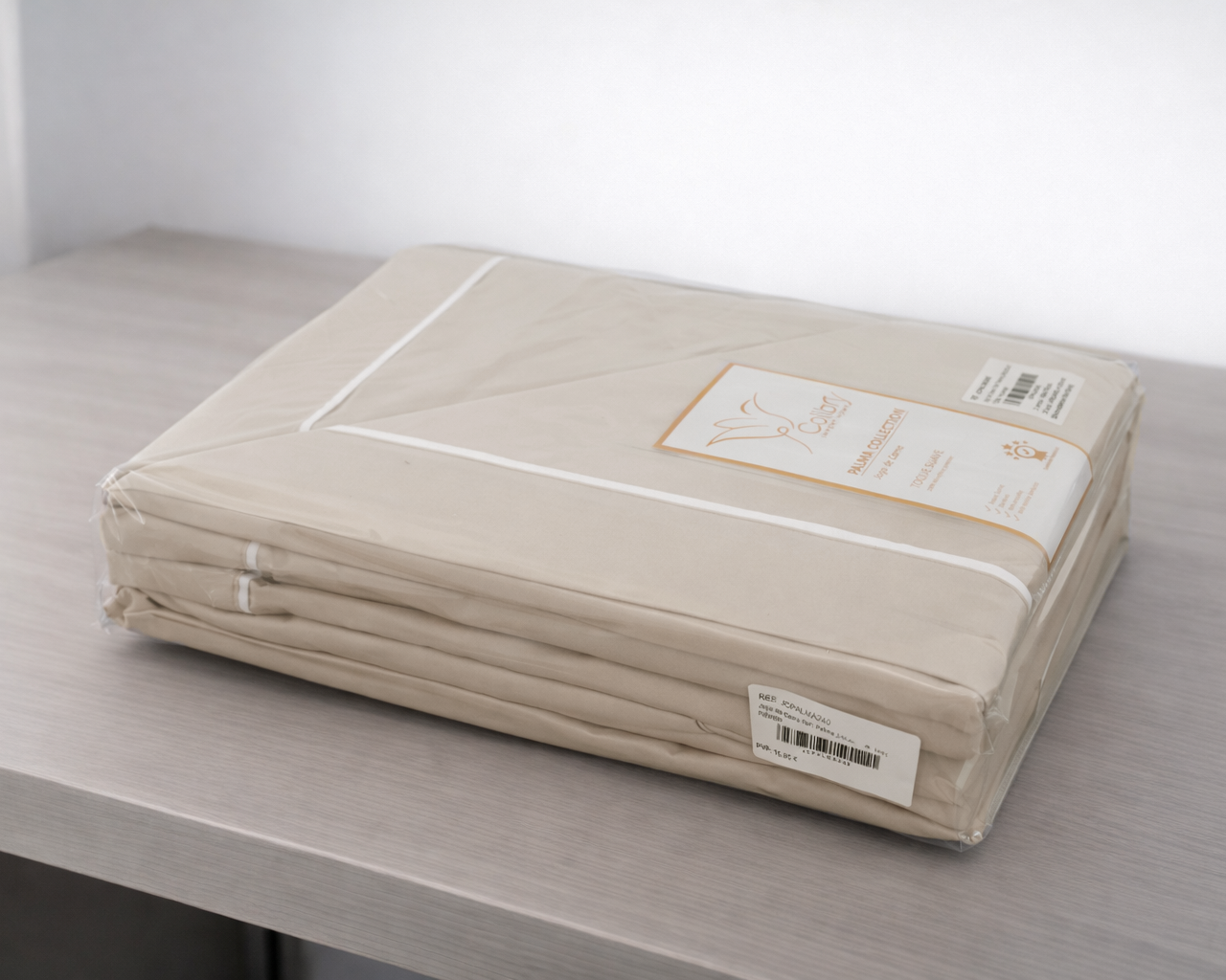 Lençol bege embalado em plástico com etiqueta, sobre superfície cinza clara