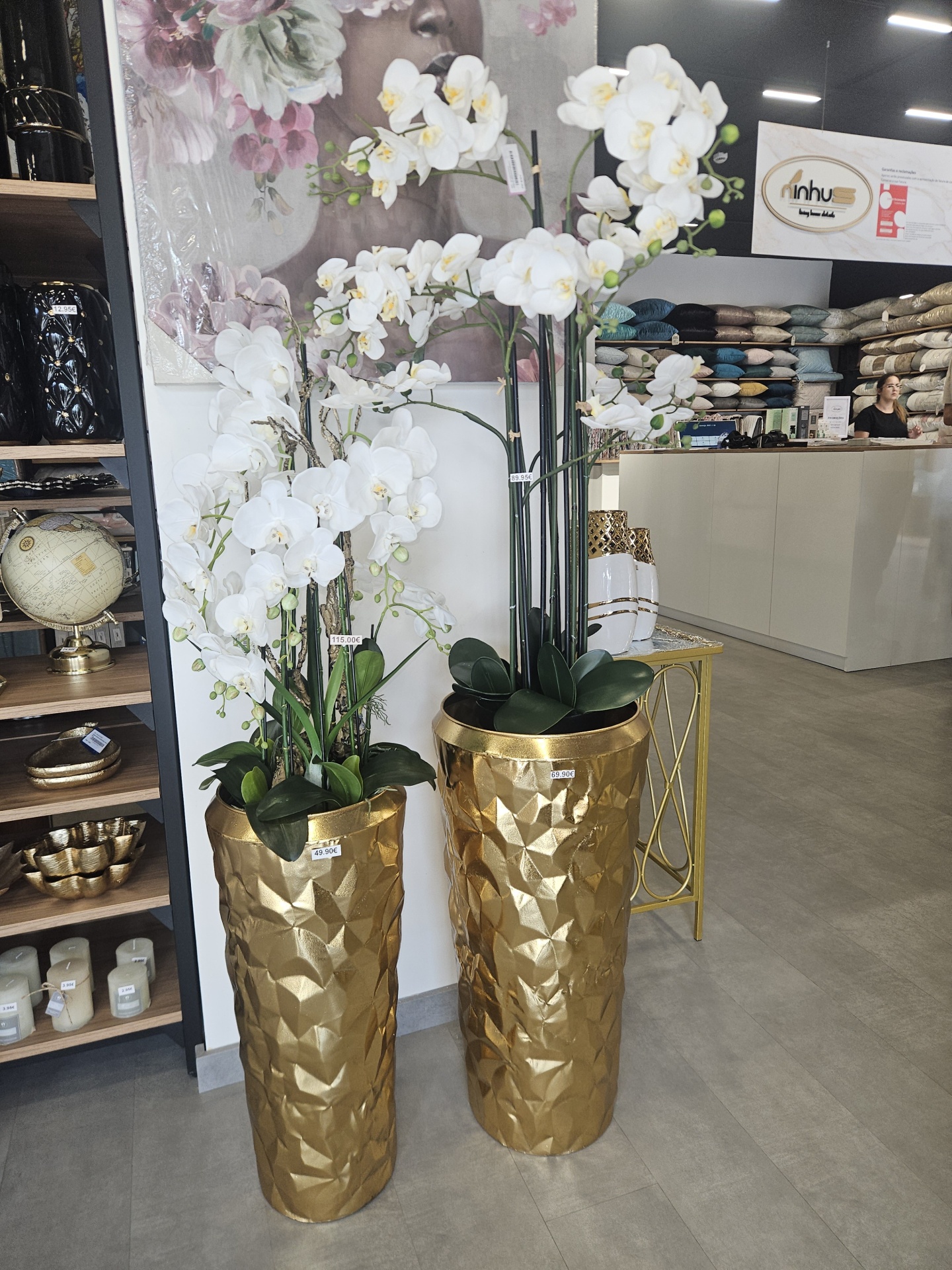 Vasos dourados com orquídeas artificiais num interior de loja