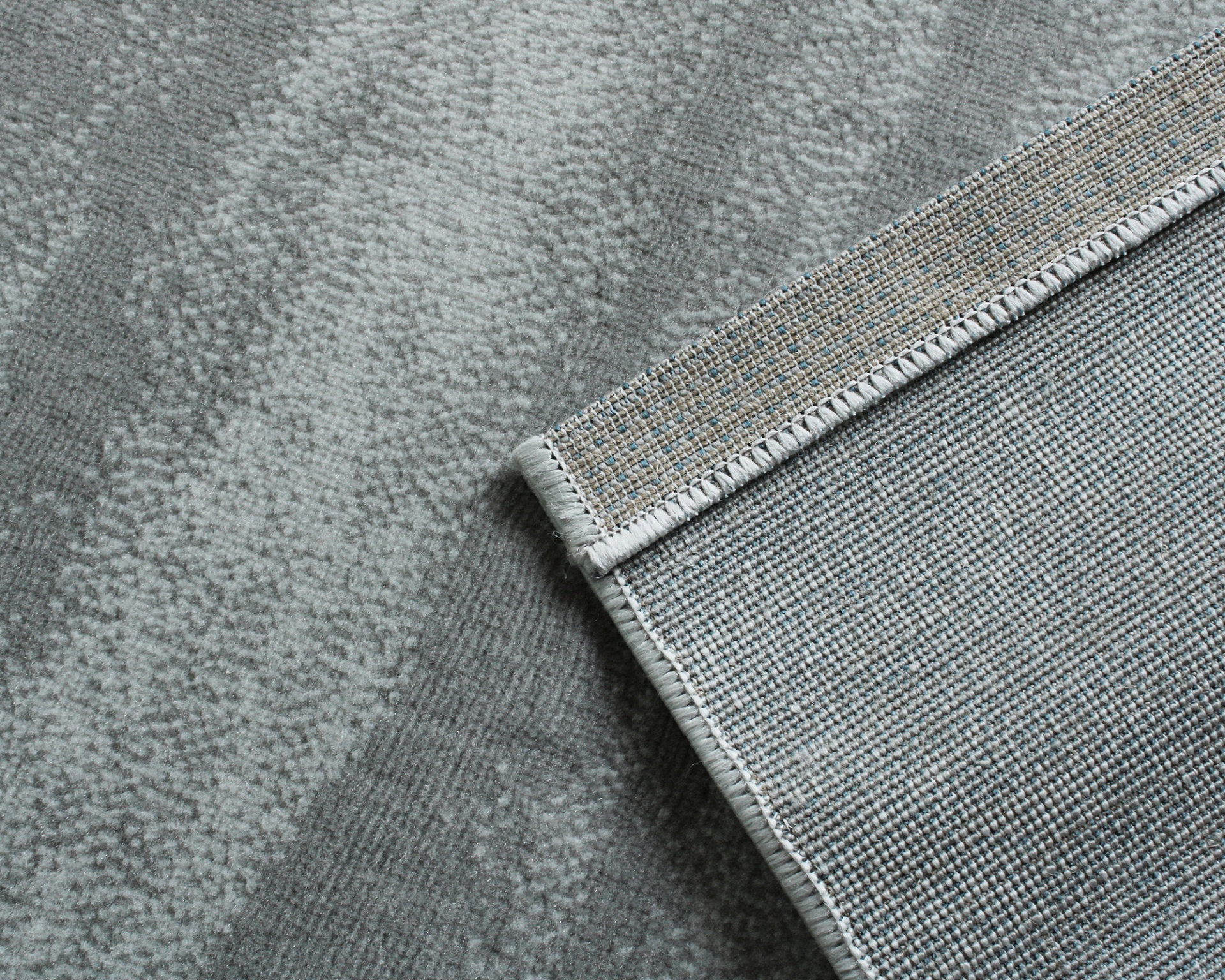 Tapete cinzento com padrão abstrato e borda bordada reforçada