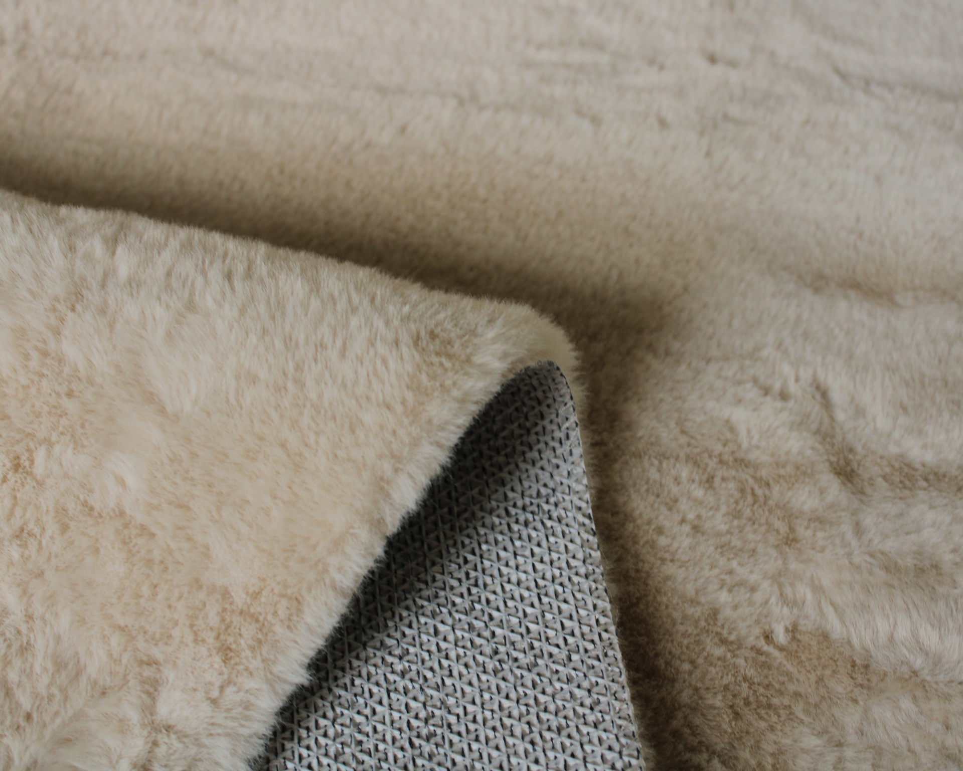Tapete ou manta bege felpuda com underside cinza de tecido com padrão