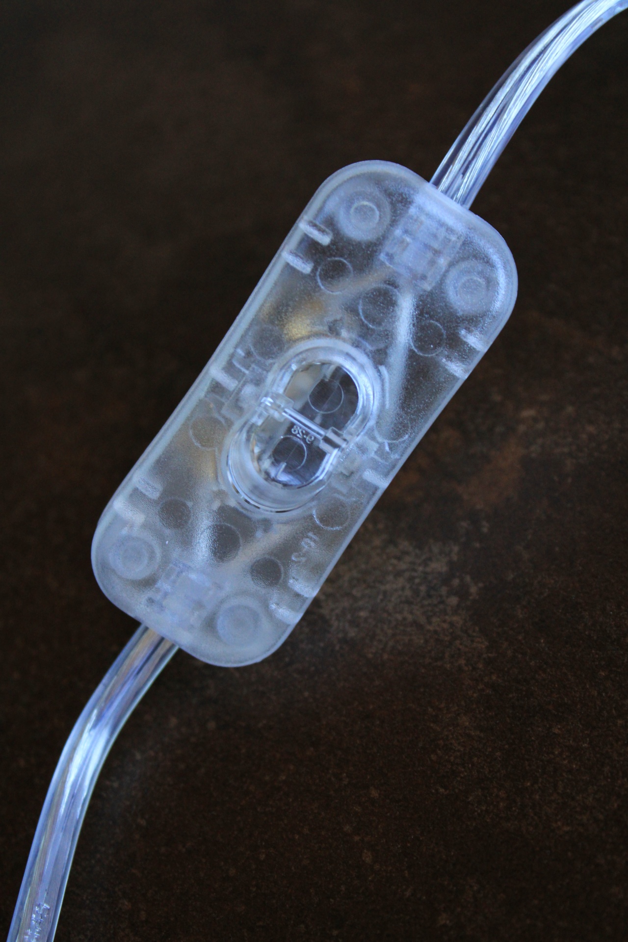 Interruptor transparente com fios sobre fundo escuro