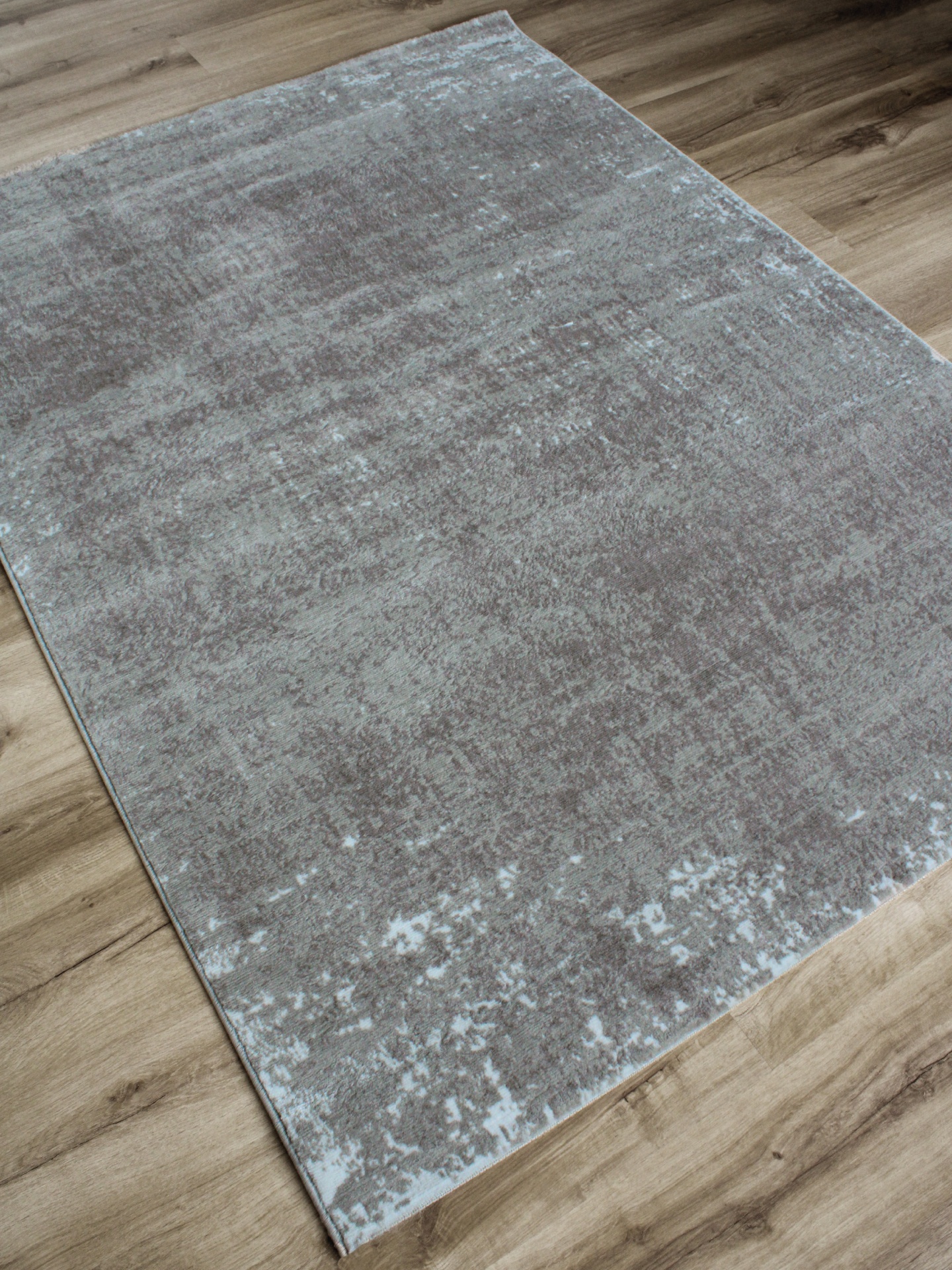 Tapete cinza sobre chão de madeira clara
