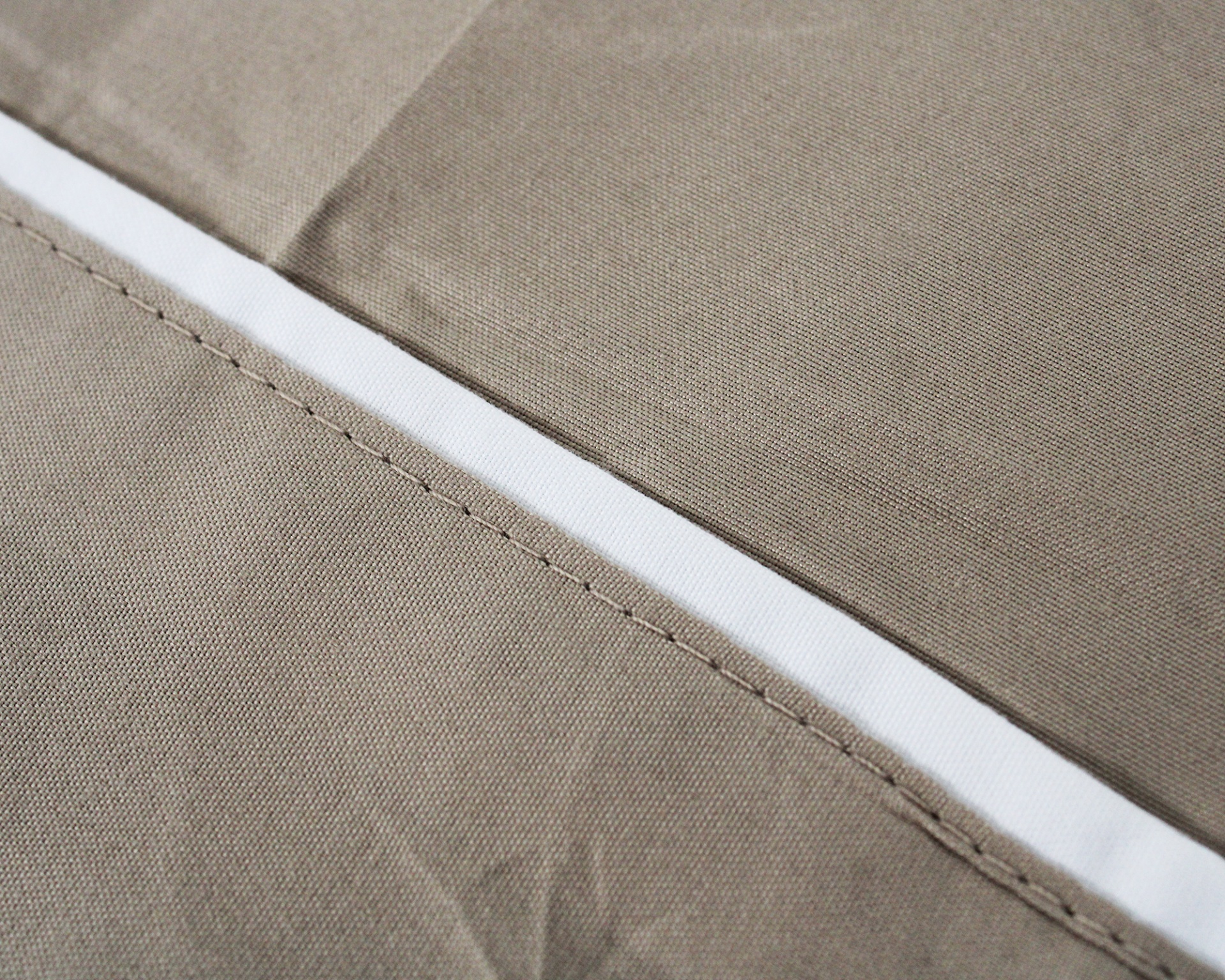 Tecido cinza com faixa branca e costura visível