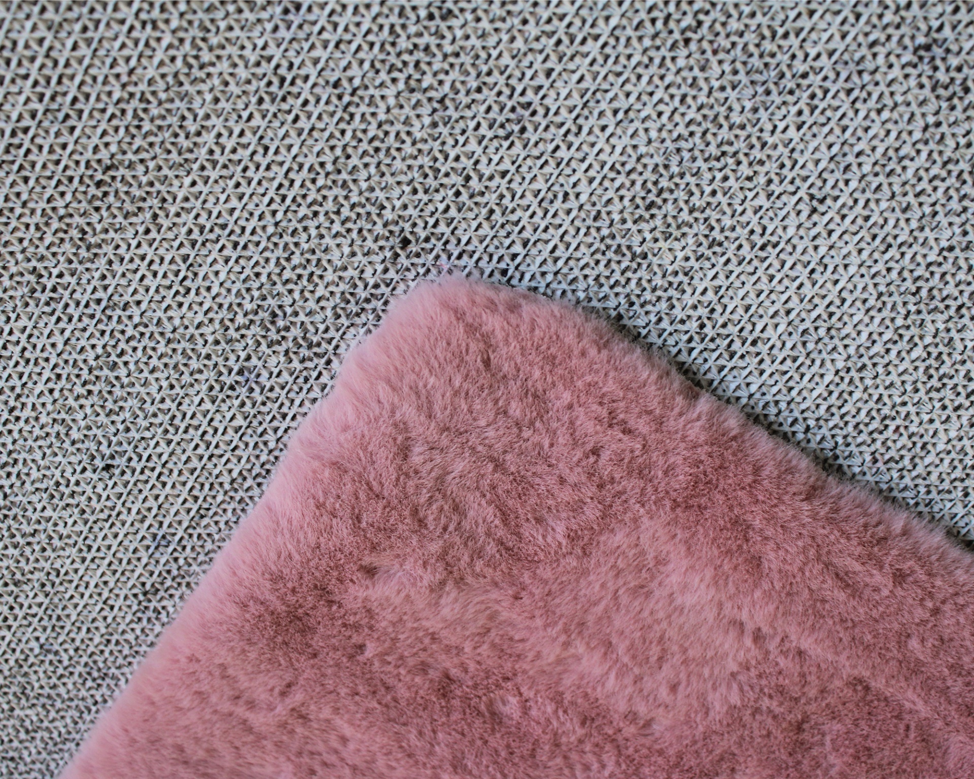 Tecido felpudo rosa sobre tecido cinza com padrão entrelaçado