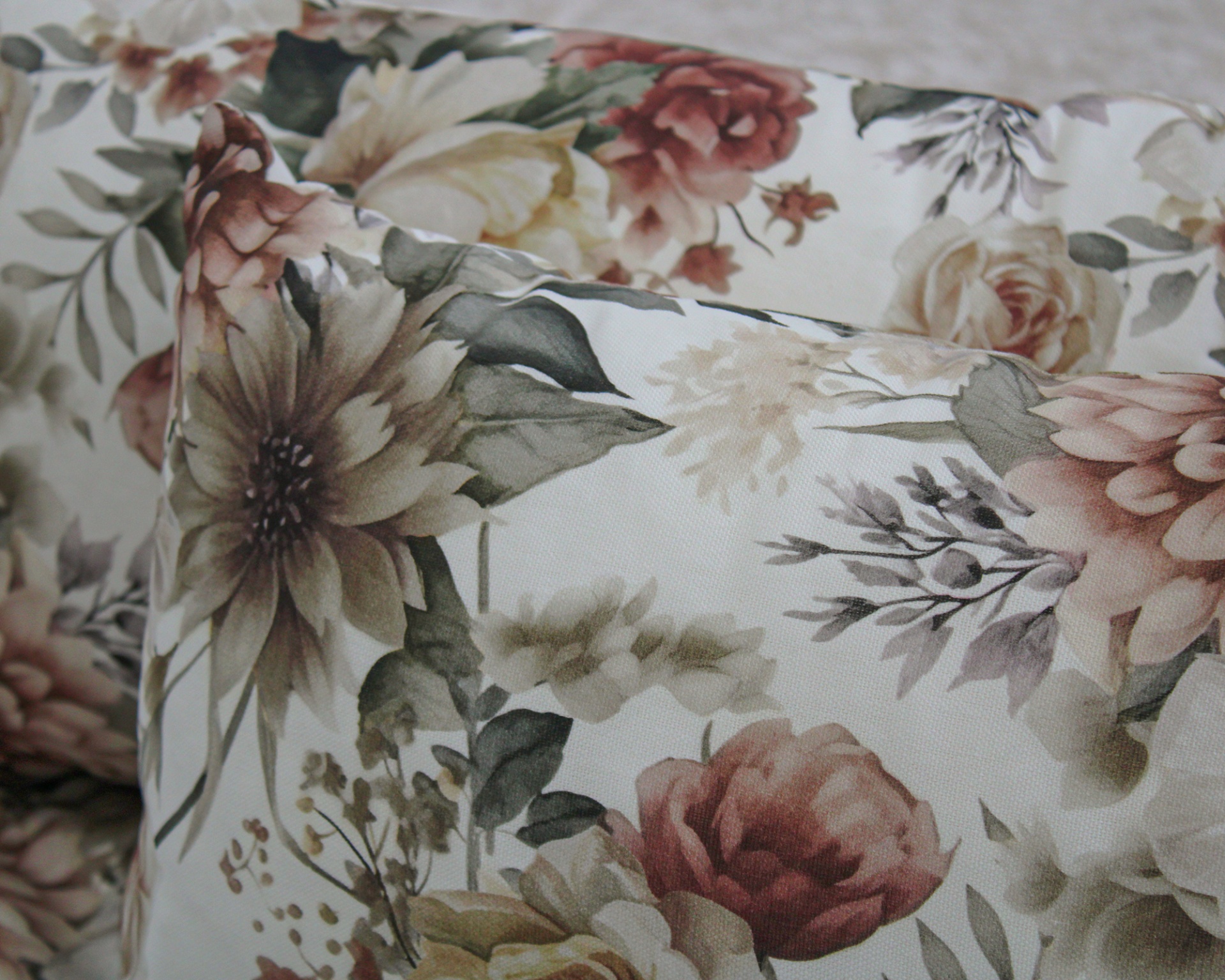 Almofadas com padrão floral em tons suaves sobre fundo branco