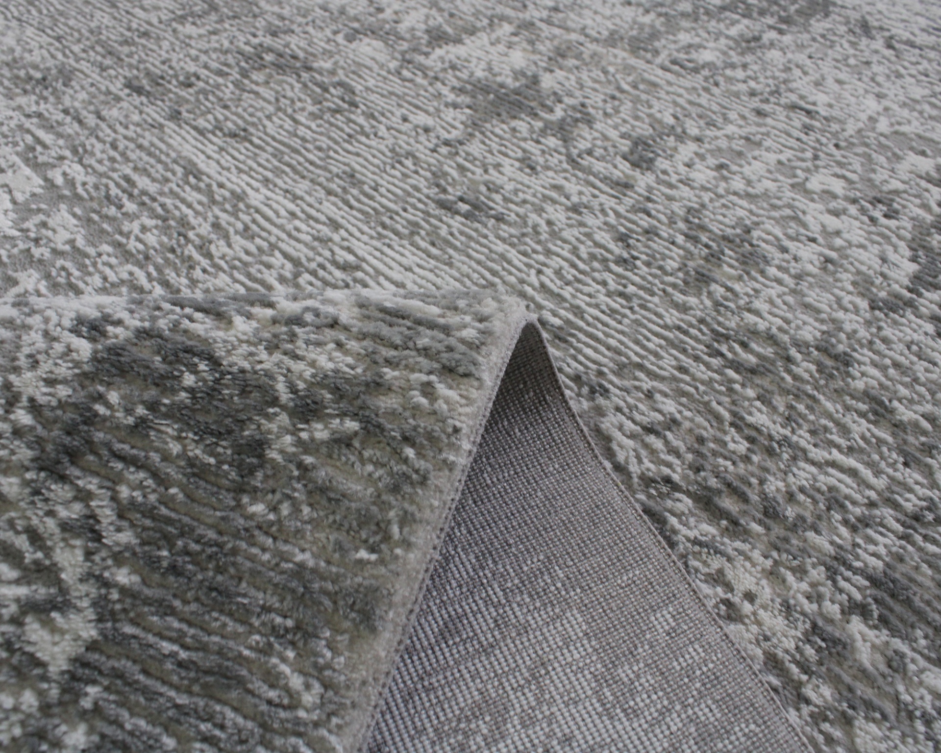 Tapete cinza com padrão texturizado abstrato e borda ligeiramente levantada