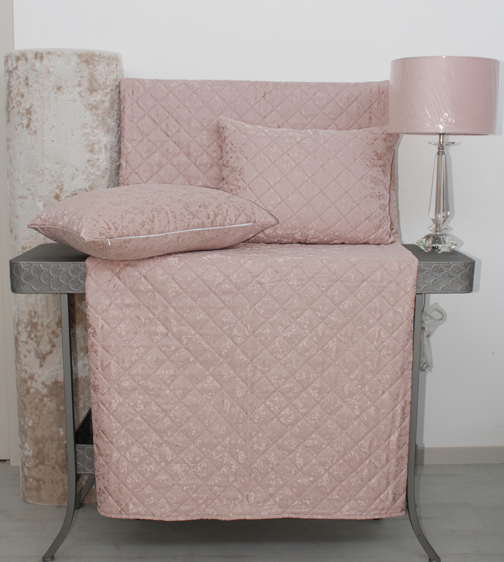 Conjunto de almofadas e capa de sofá rosa com padrão matelassê, móvel cinzento, rolo de tapete bege, lâmpada com cúpula rosa