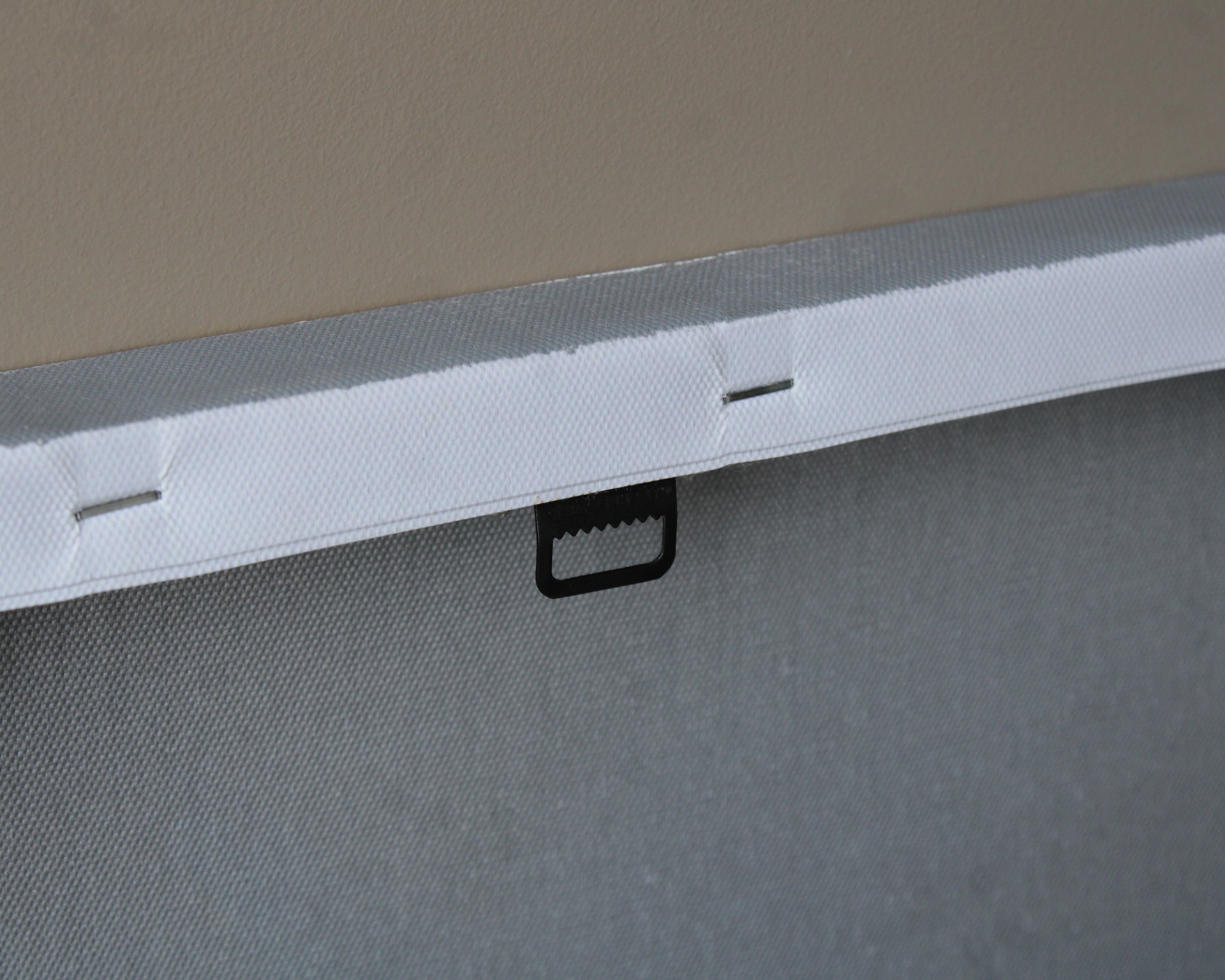 Tela de pintura com tecido cinza esticado e faixa branca na parte superior