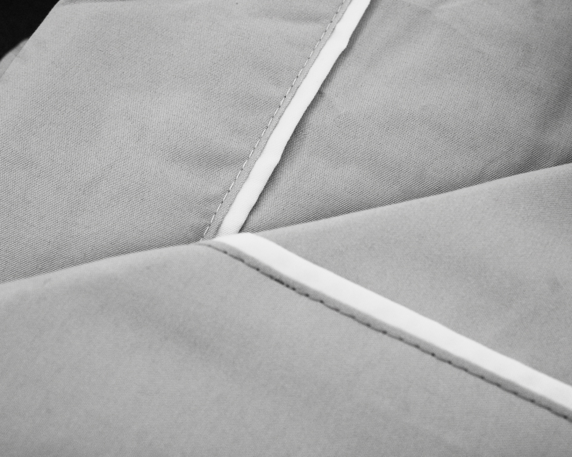 Tecido cinza com linhas de costura e detalhe branco
