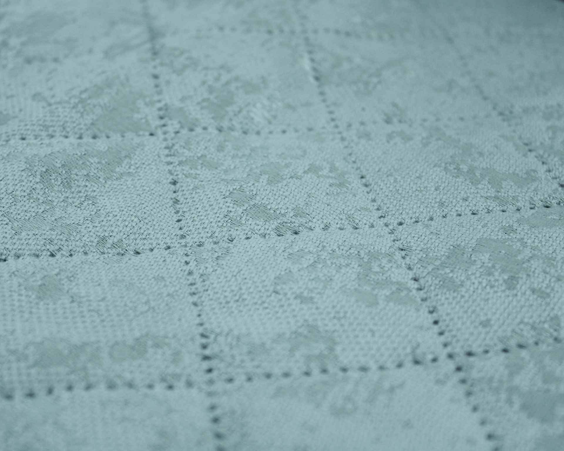 Tecido azul claro com padrão floral em relevo e quadrícula