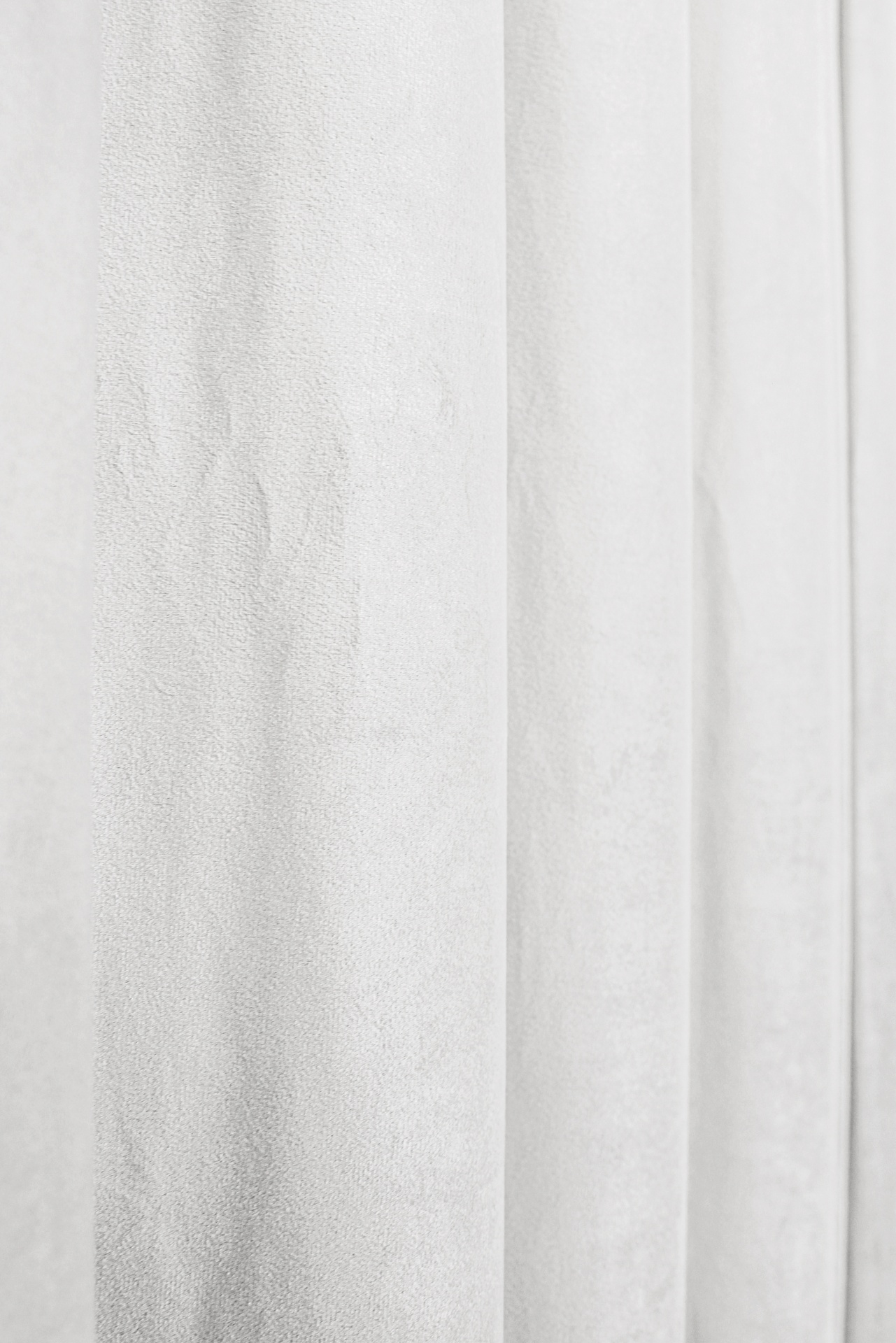 Cortina branca de tecido com textura suave e pregas verticais