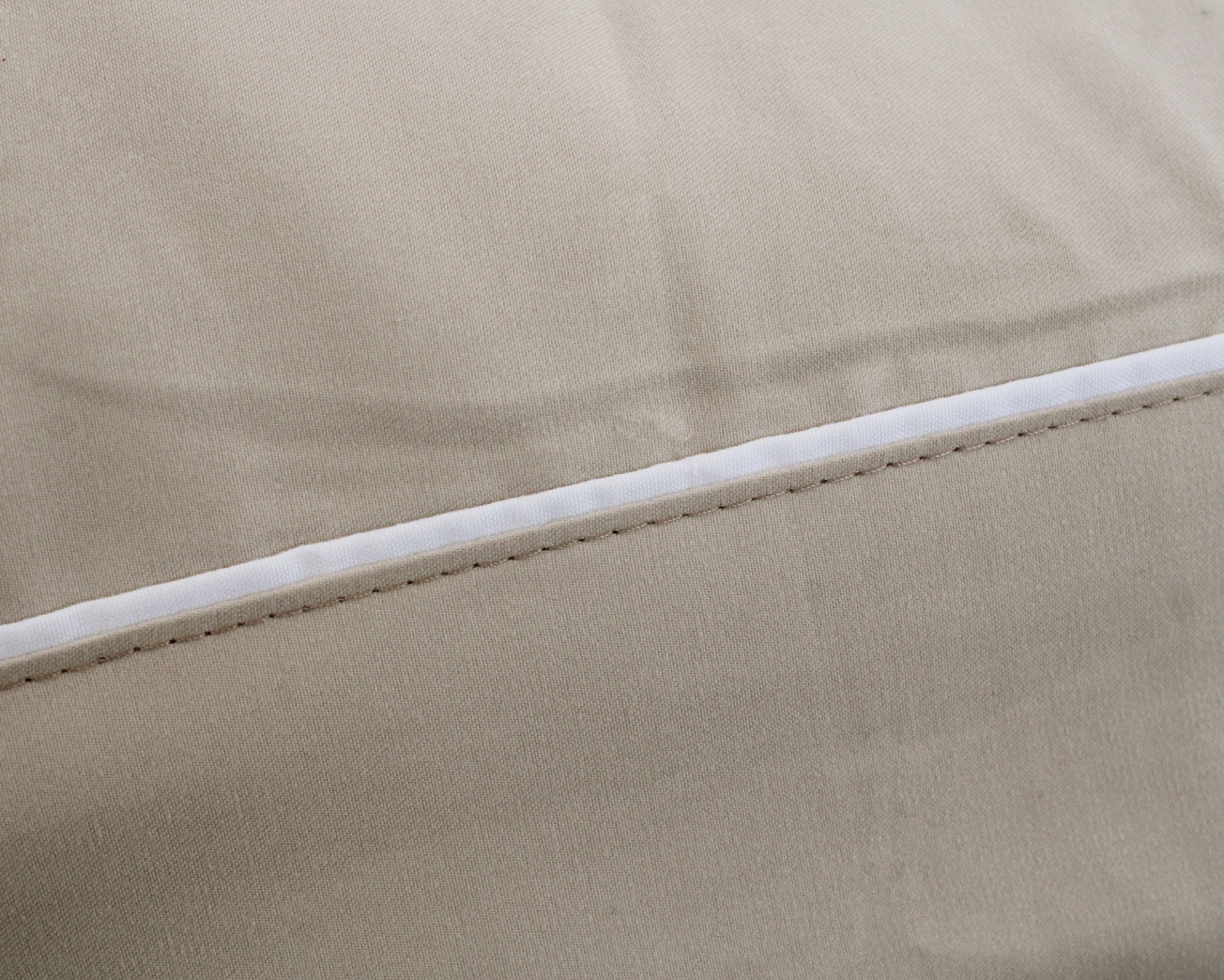 Tecido bege com costura reta e fita branca