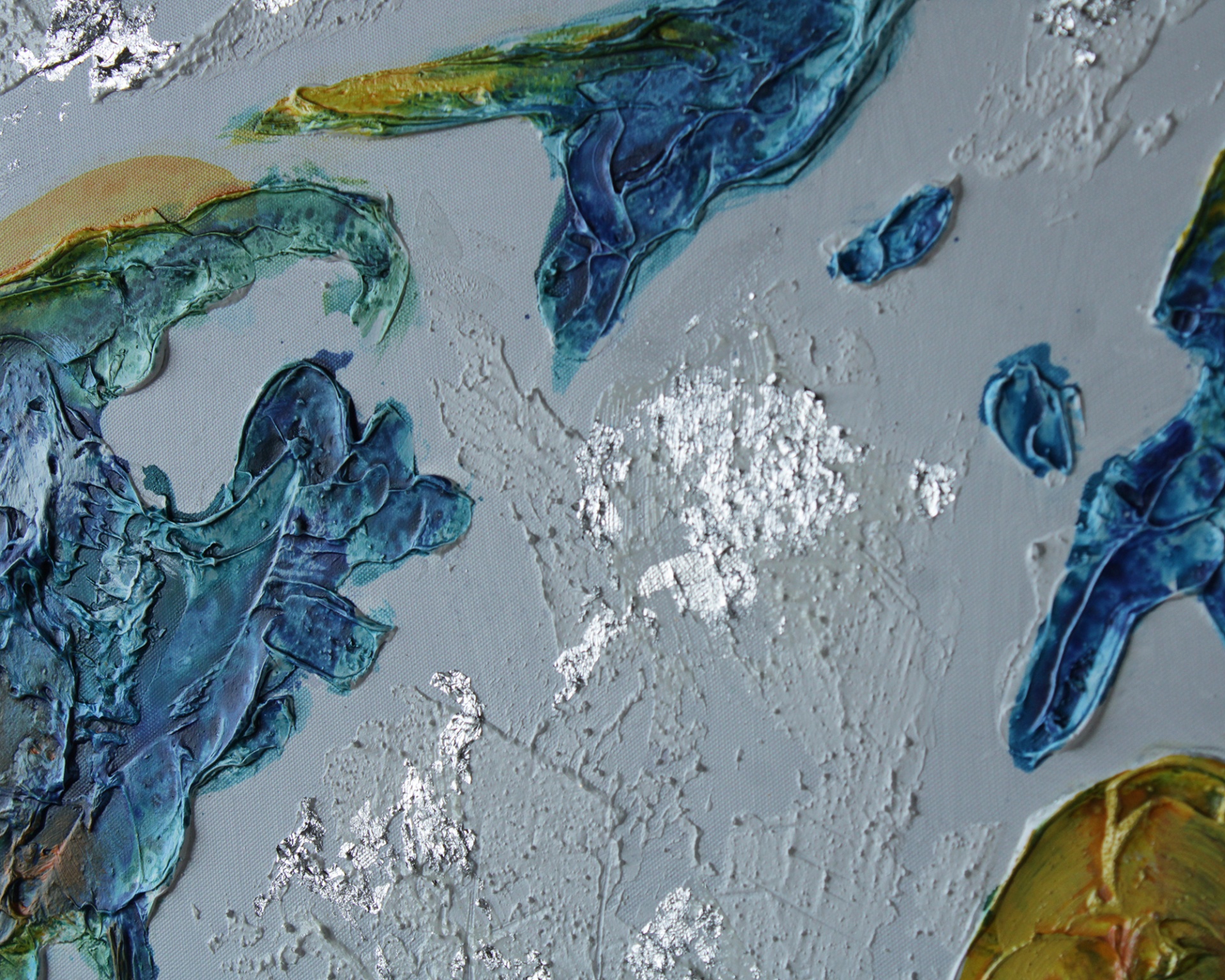 Detalhe de pintura abstrata com textura em azul, verde, amarelo e dourado sobre fundo cinzento.
