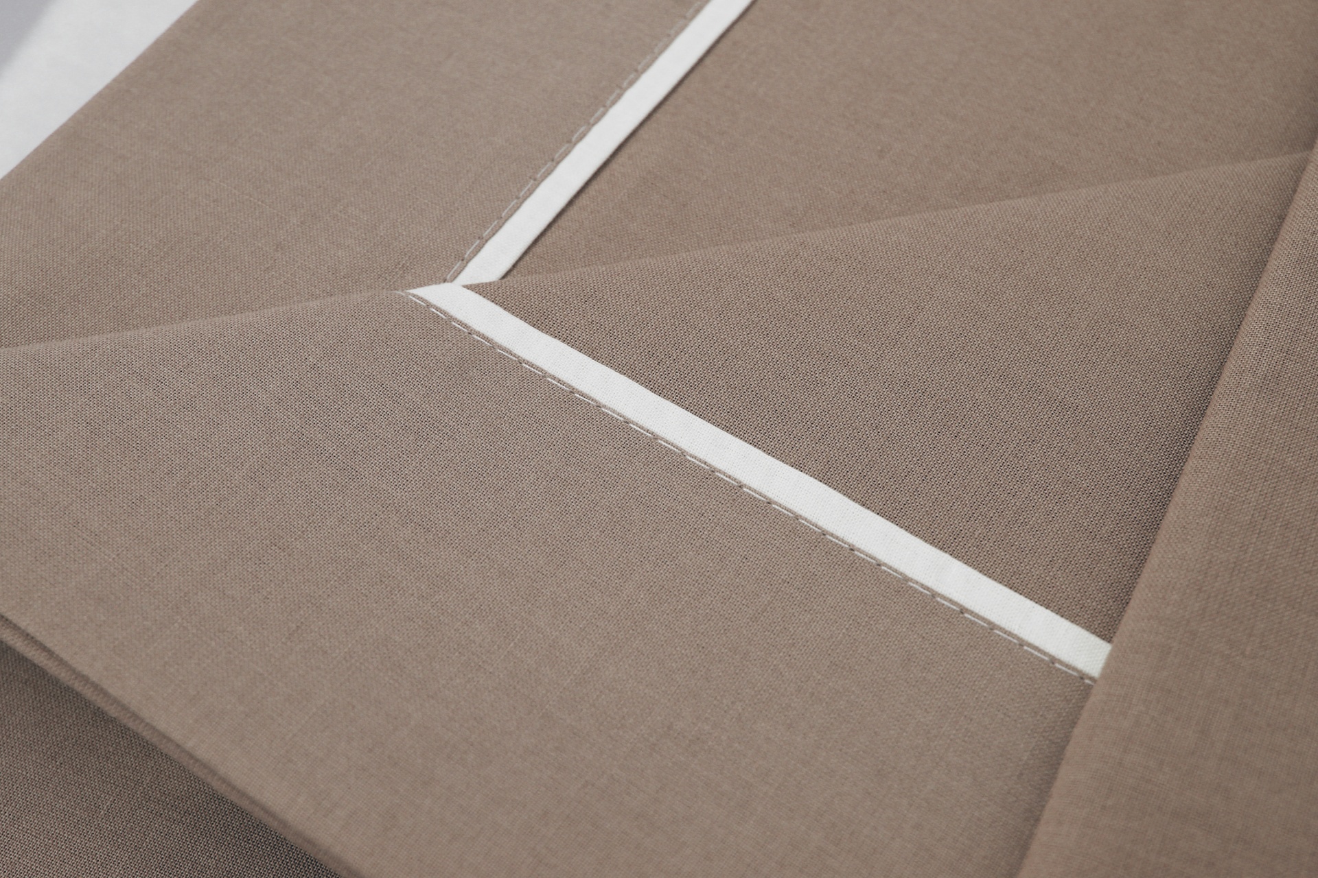 tecido castanho claro com linha de costura branca