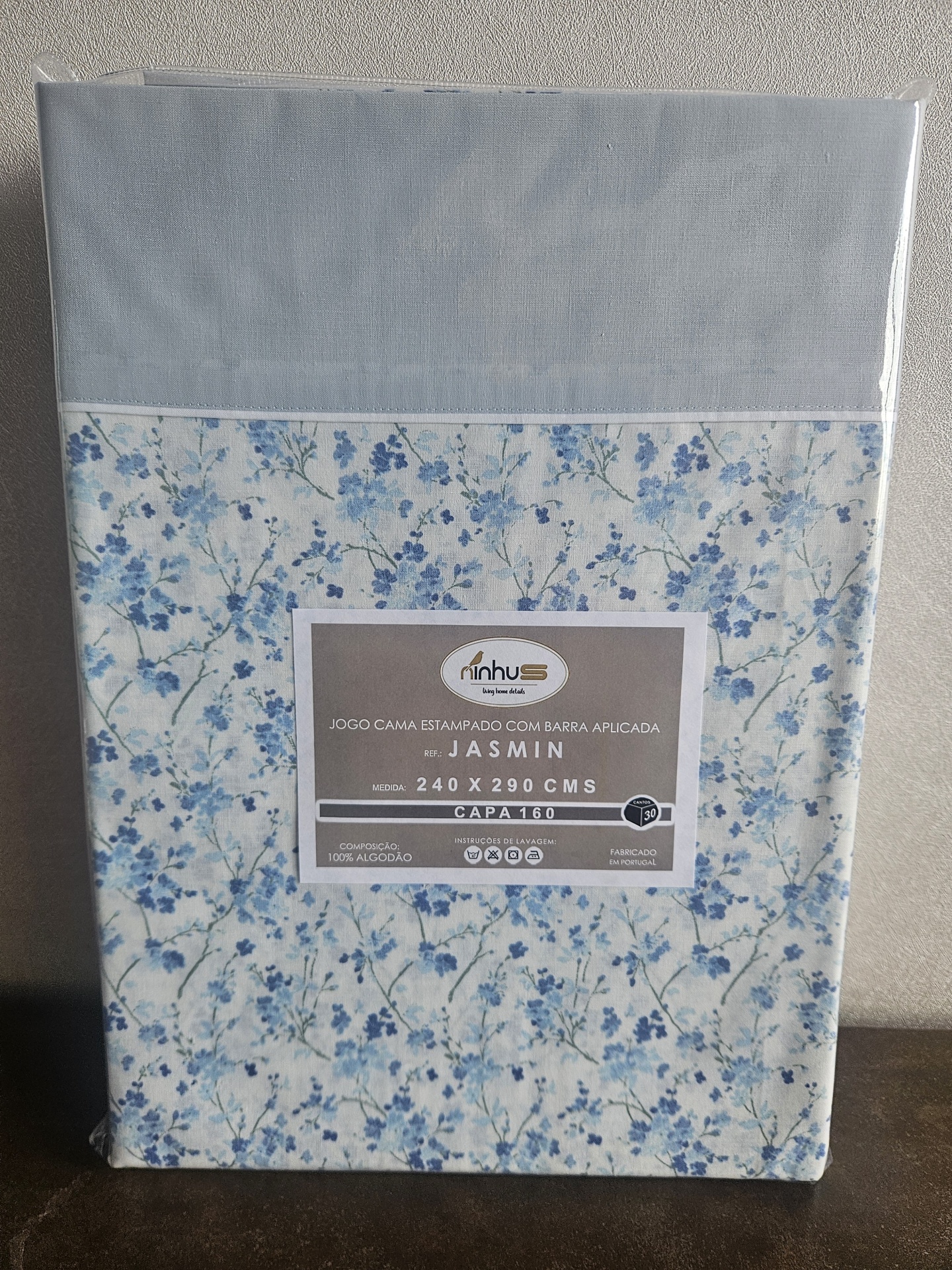Jogo de cama estampado com flores azuis e etiqueta com informações do produto