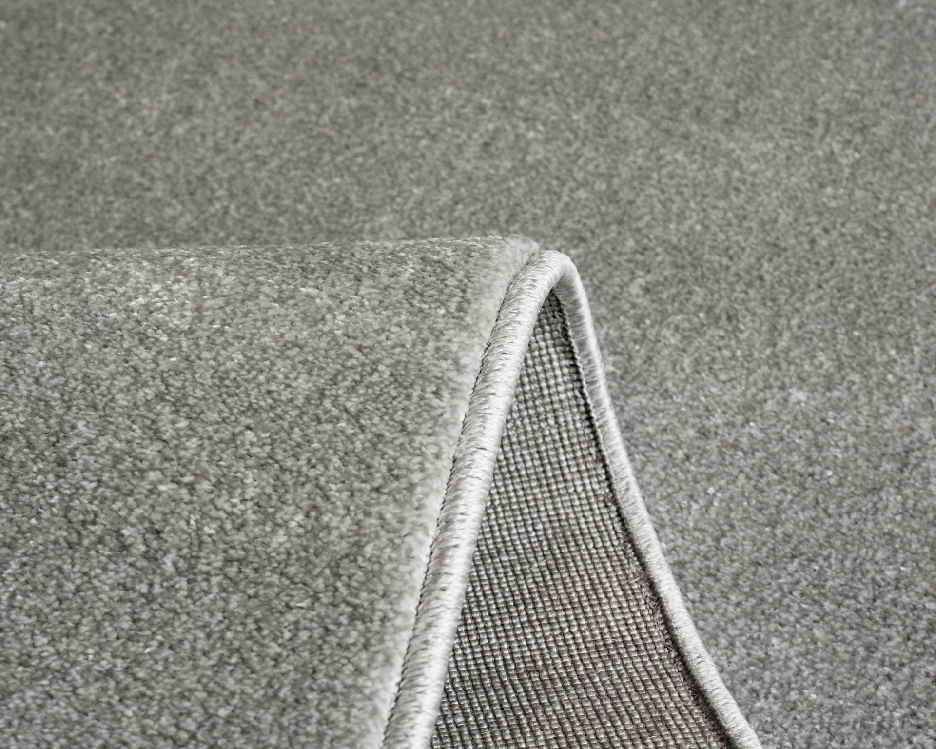 Tapete cinzento aveludado com borda rematada dobrado