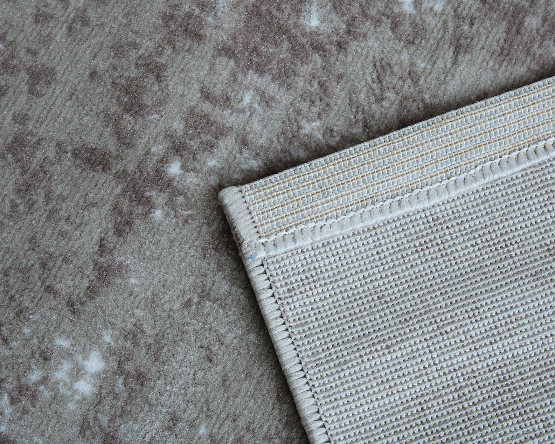 Tapete cinzento com padrão de manchas e borda de textura malha