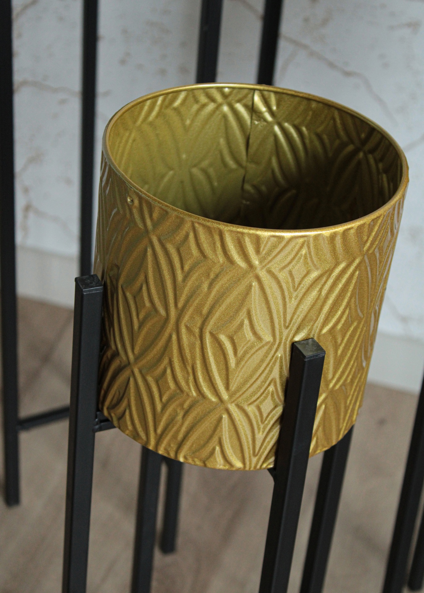 Vaso decorativo dourado texturizado com suporte metálico preto