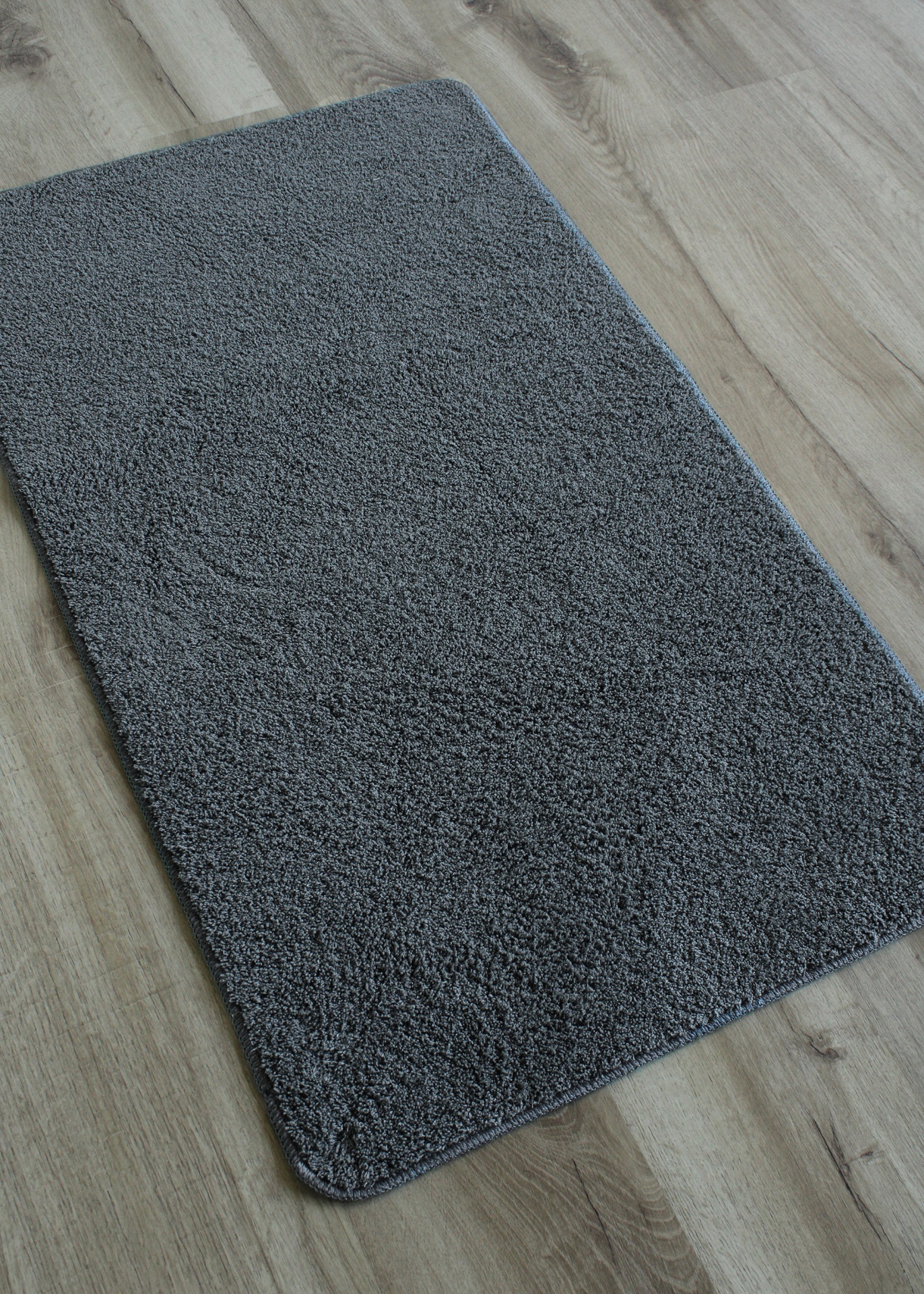 tapete cinzento de pelo alto sobre chão de madeira