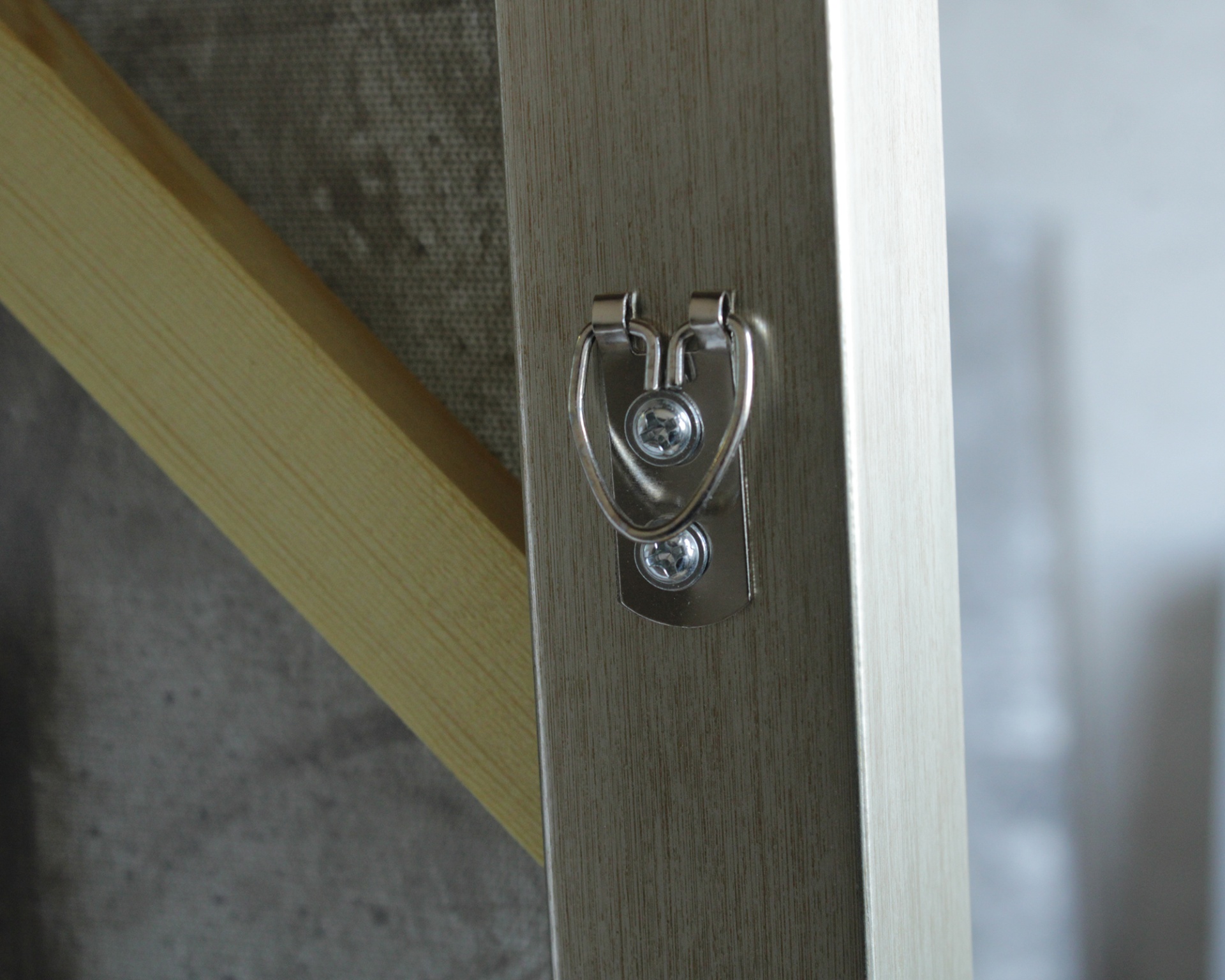 Suporte metálico prateado fixado em madeira clara