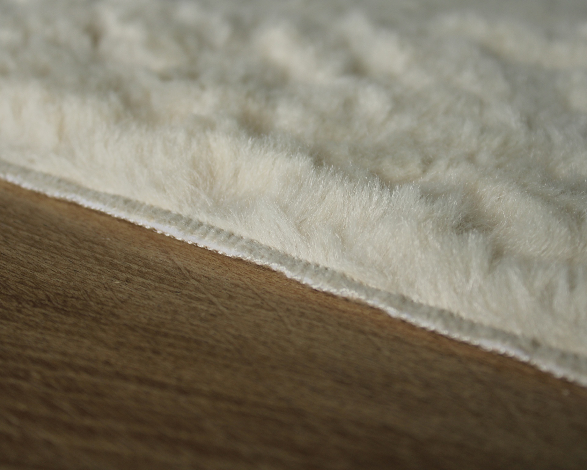 tapete ou manta felpuda branca perto de piso de madeira