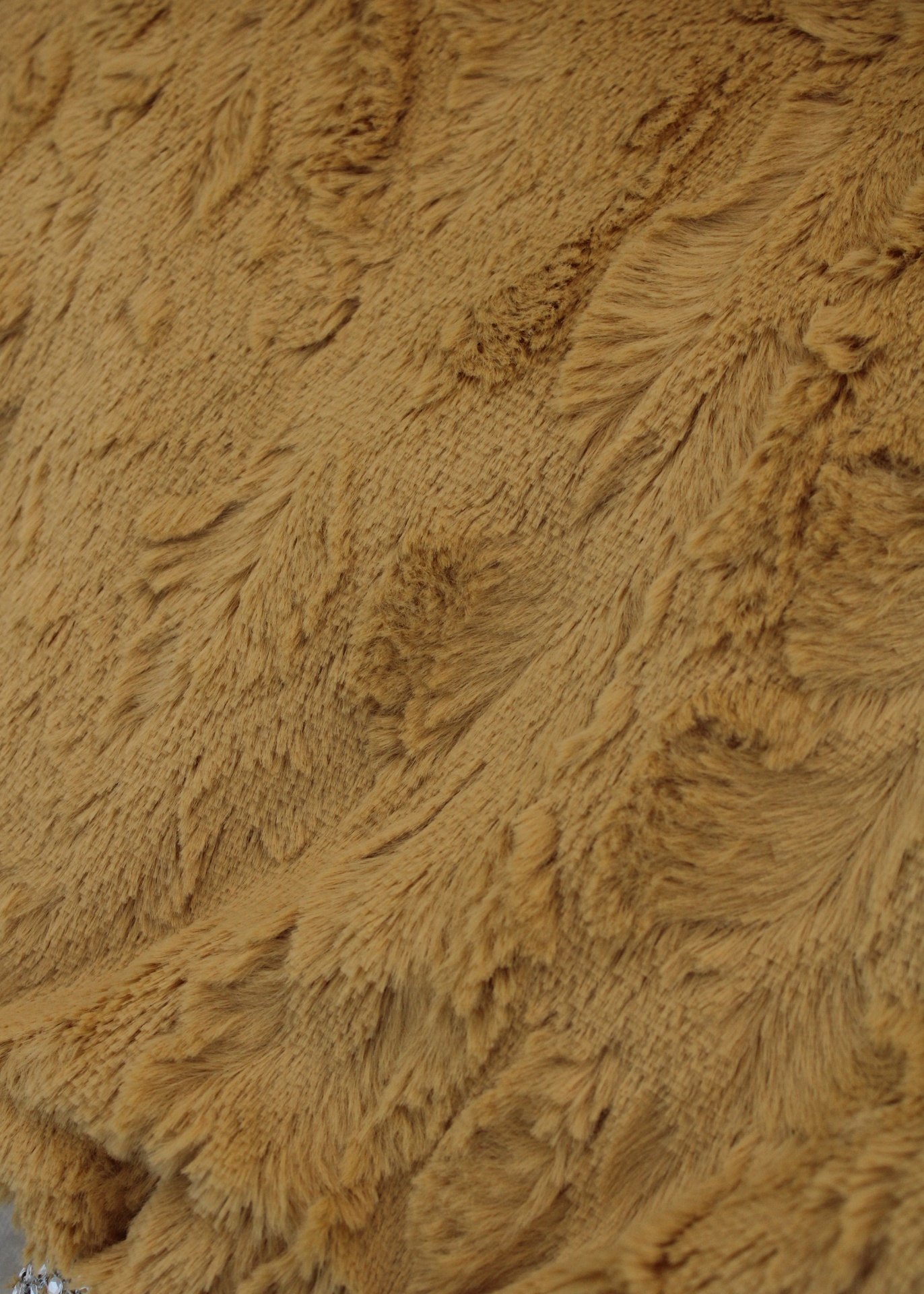 Tecido de pêlo sintético castanho com padrão texturado irregular