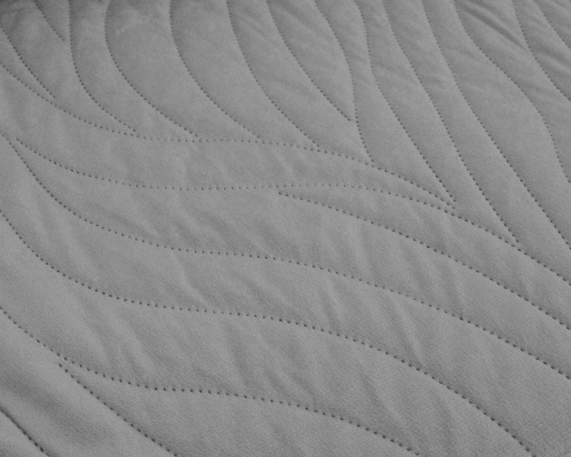 tecido cinzento claro acolchoado com padrão de linhas onduladas