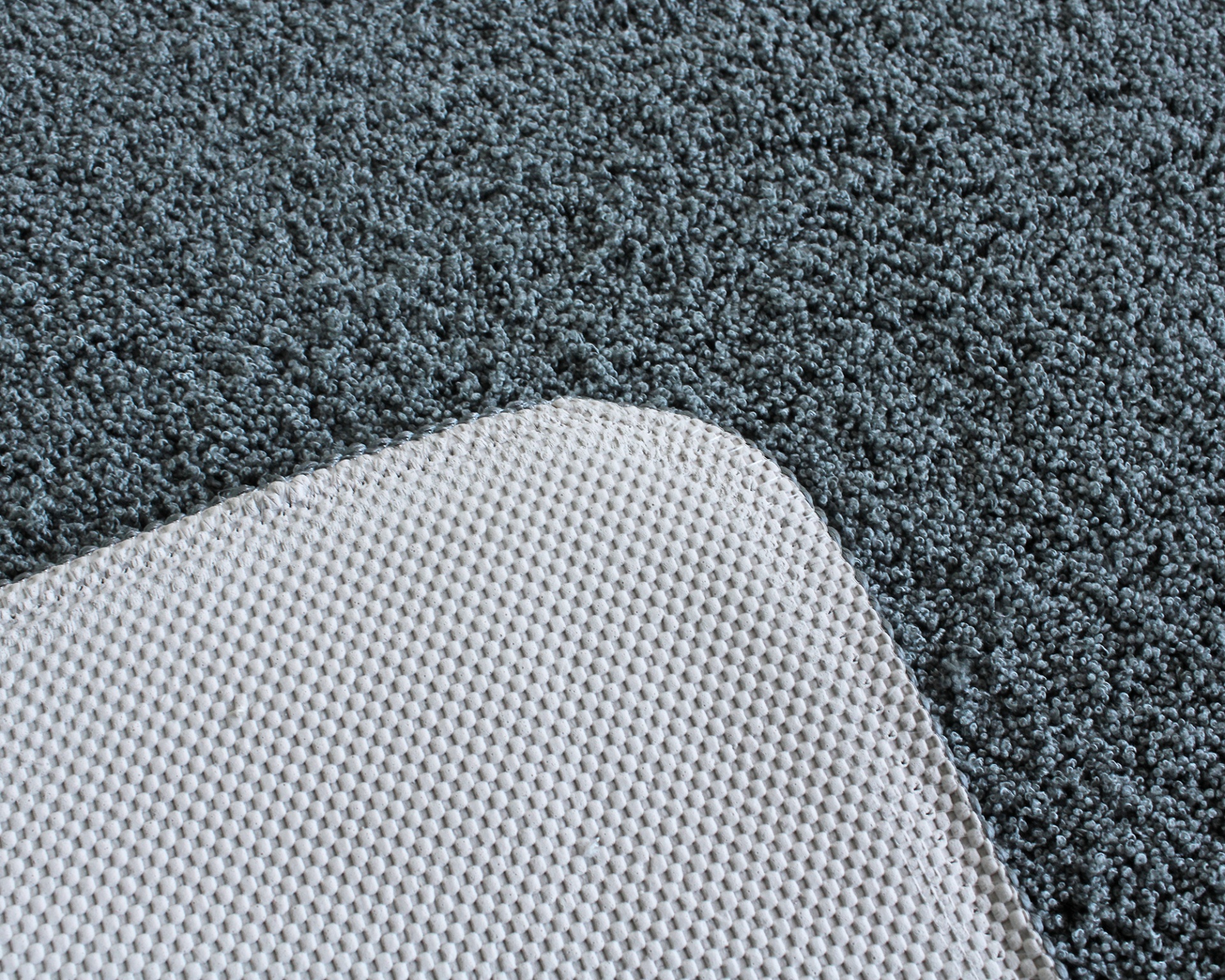 Tapete cinzento escuro felpudo com canto de tapete branco texturizado