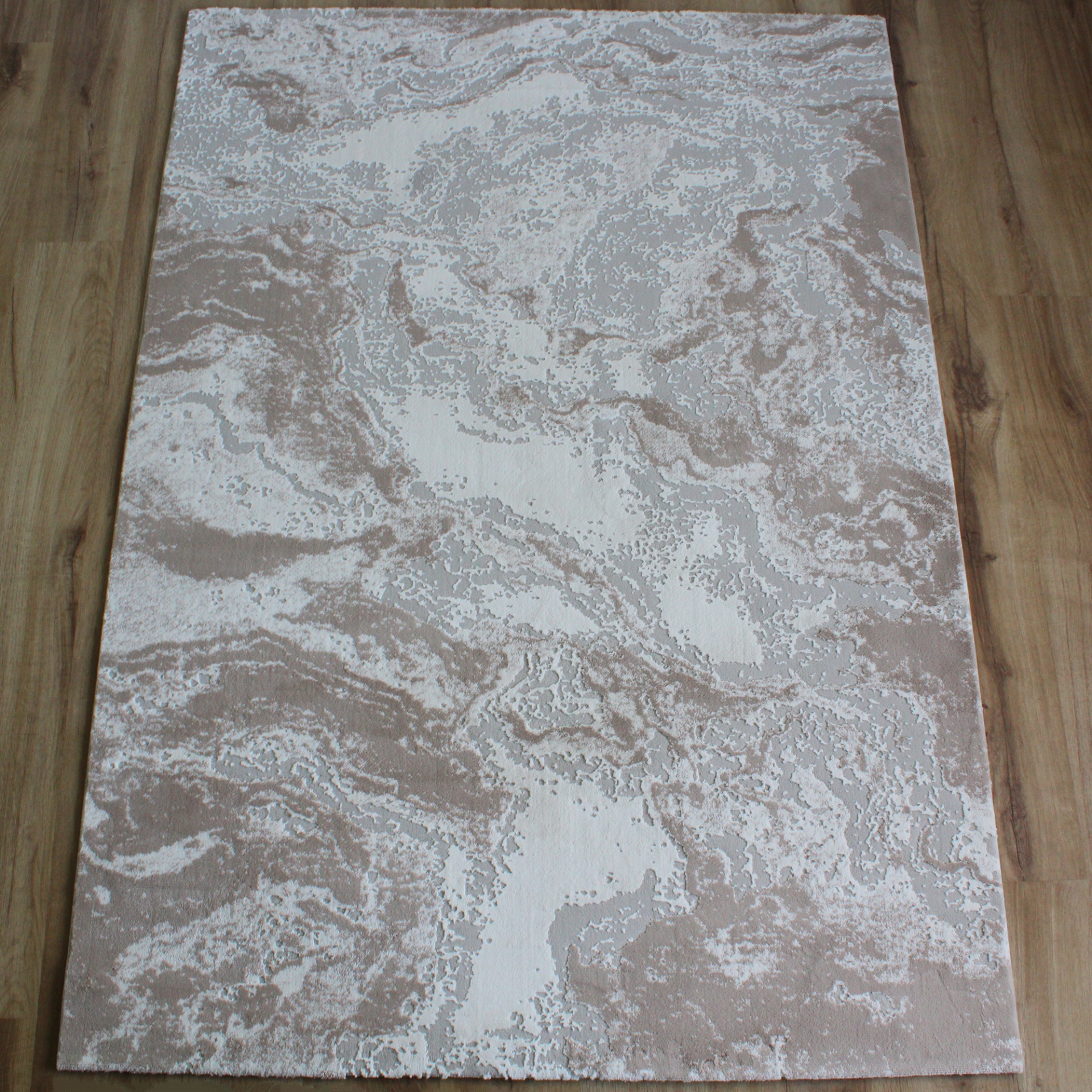 Tapete com padrão abstrato cinza e bege em chão de madeira