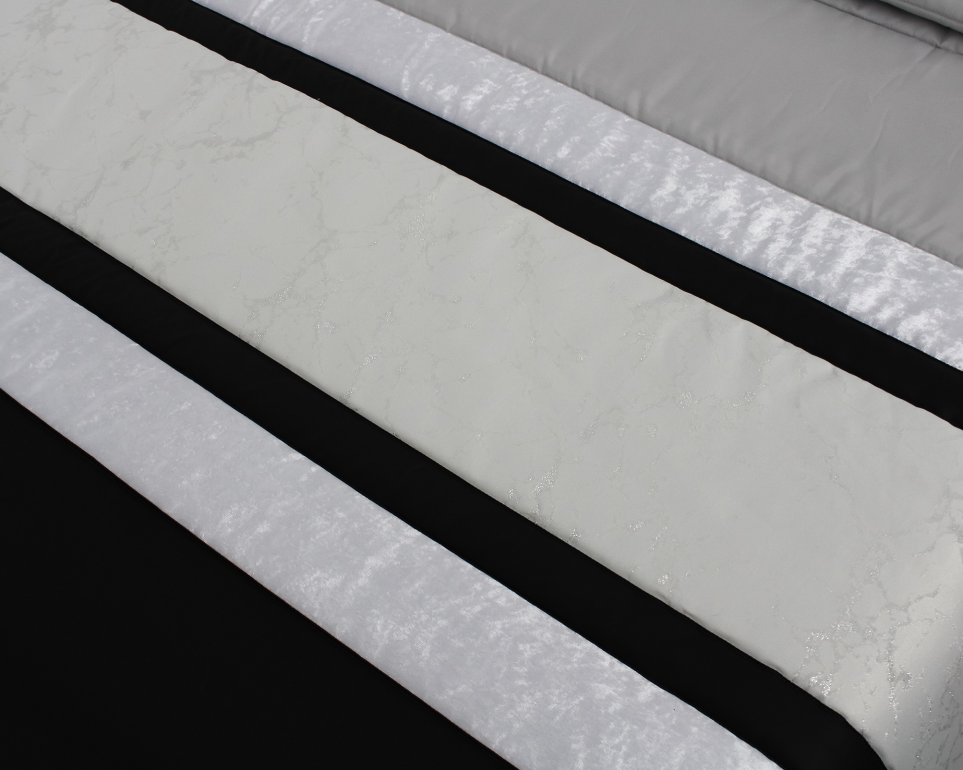 Colcha listrada em branco, preto e cinzento com padrão marmoreado