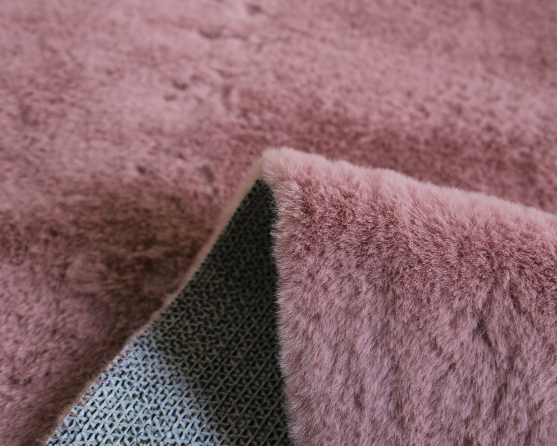 Tapete felpudo rosa com verso cinza e padrão de grade