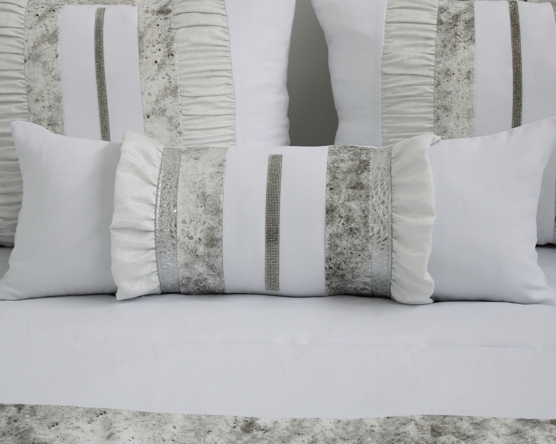 Conjunto de almofadas brancas e cinza com texturas e riscas
